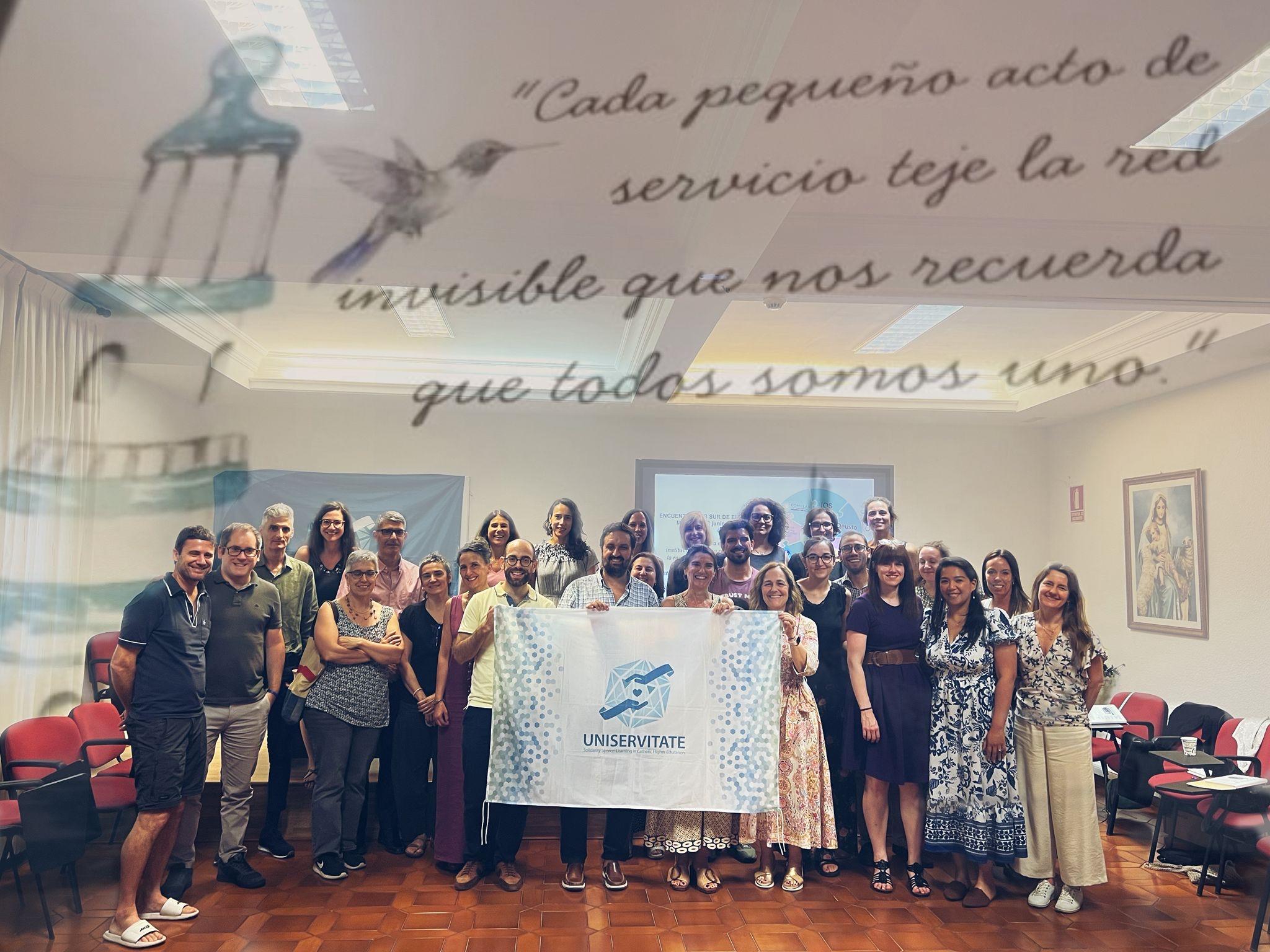 Un grupo diverso de personas se reúne con una pancarta de la organización UNSERVITATE, en un ambiente de colaboración y reflexión.