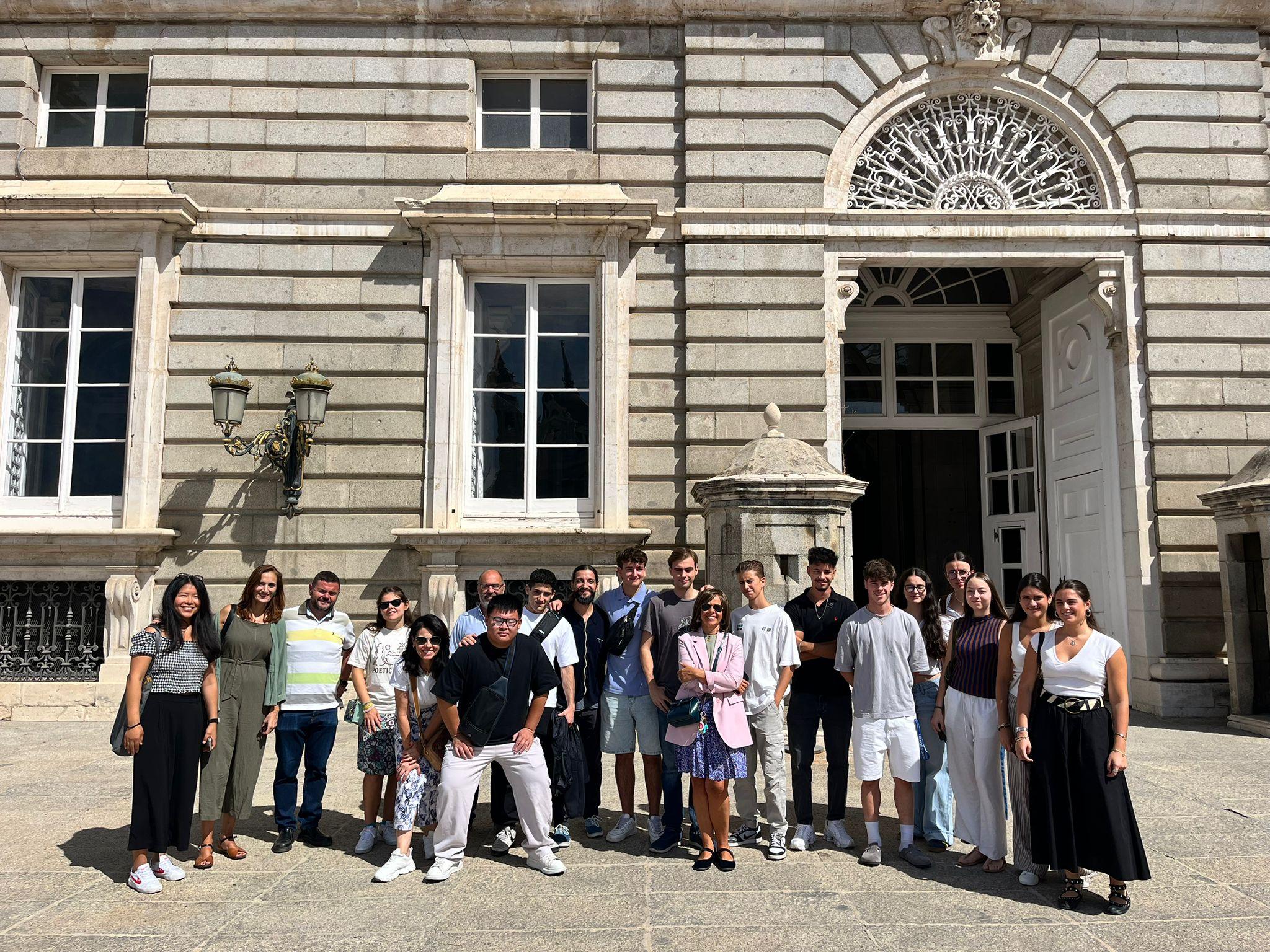Grupo de personas posando frente a un edificio histórico.