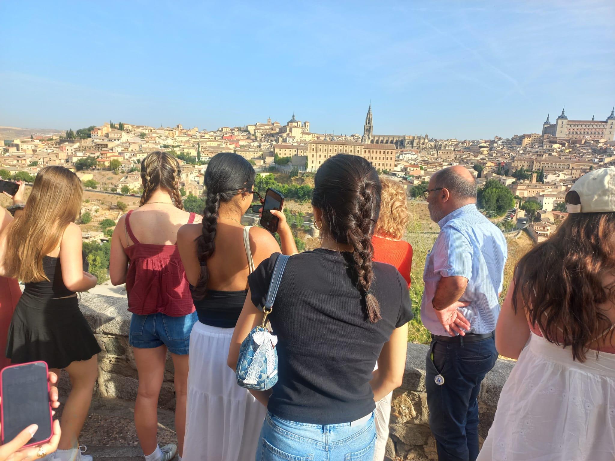 Un grupo de personas observa una ciudad desde un mirador.