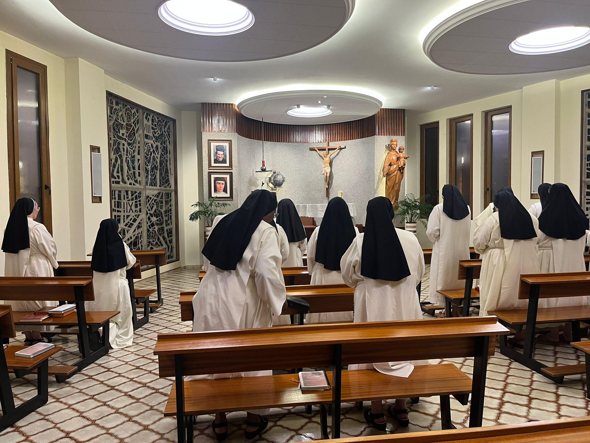 Un grupo de monjas en un momento de oración en un recinto religioso.