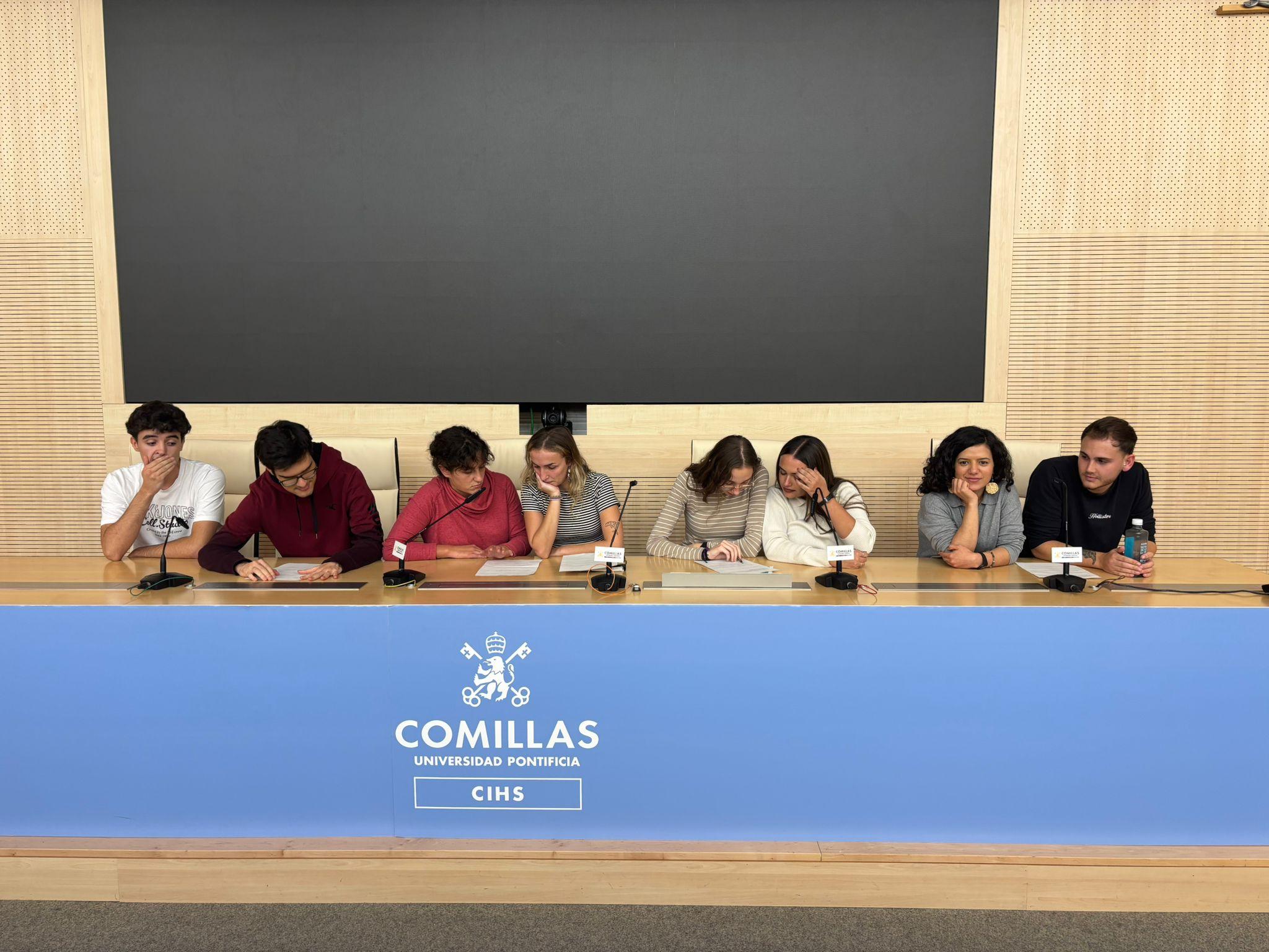 Un grupo de estudiantes sentados en una mesa durante un evento en la Universidad Pontificia Comillas.