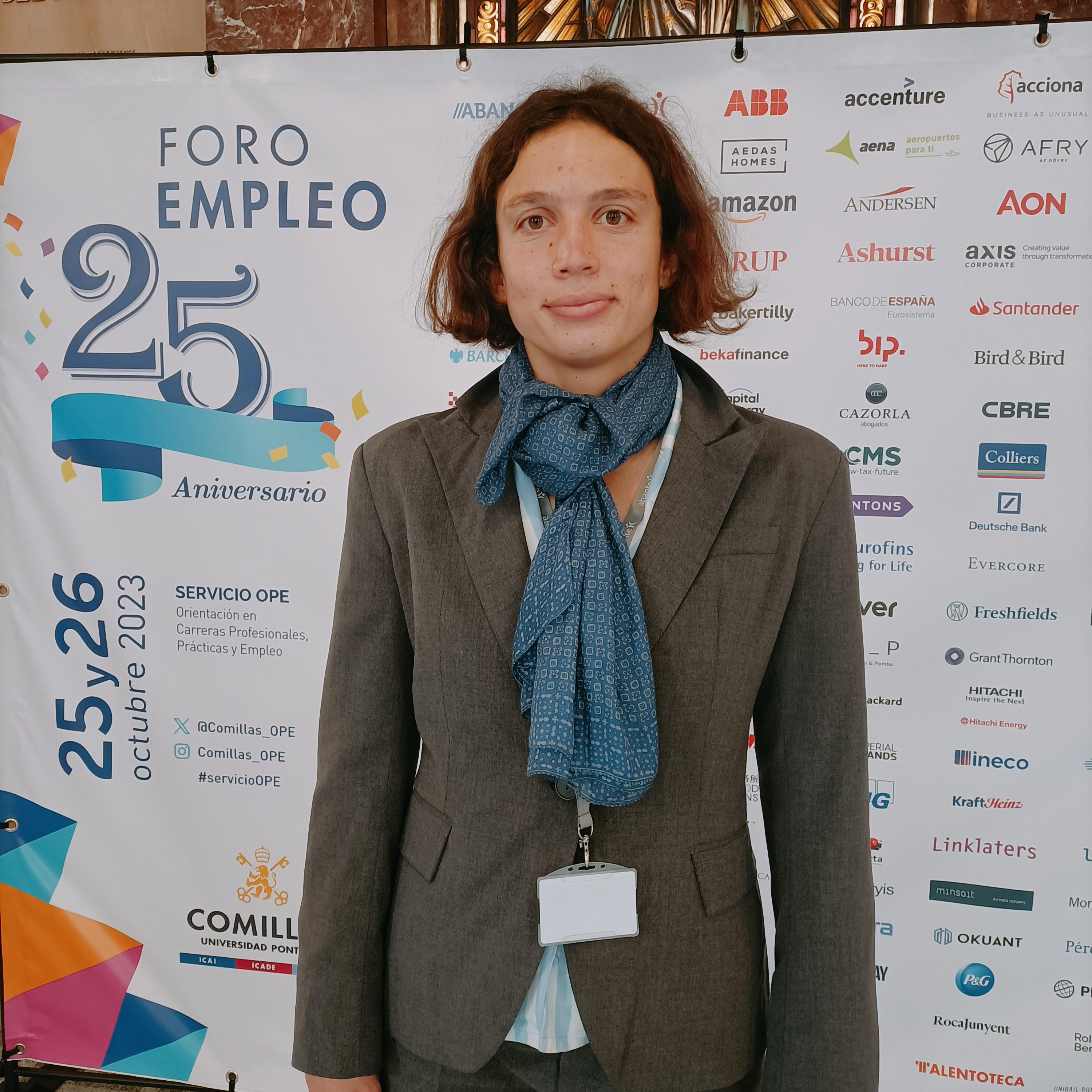 A person in a suit stands in front of a banner celebrating the 25th anniversary of a job fair.