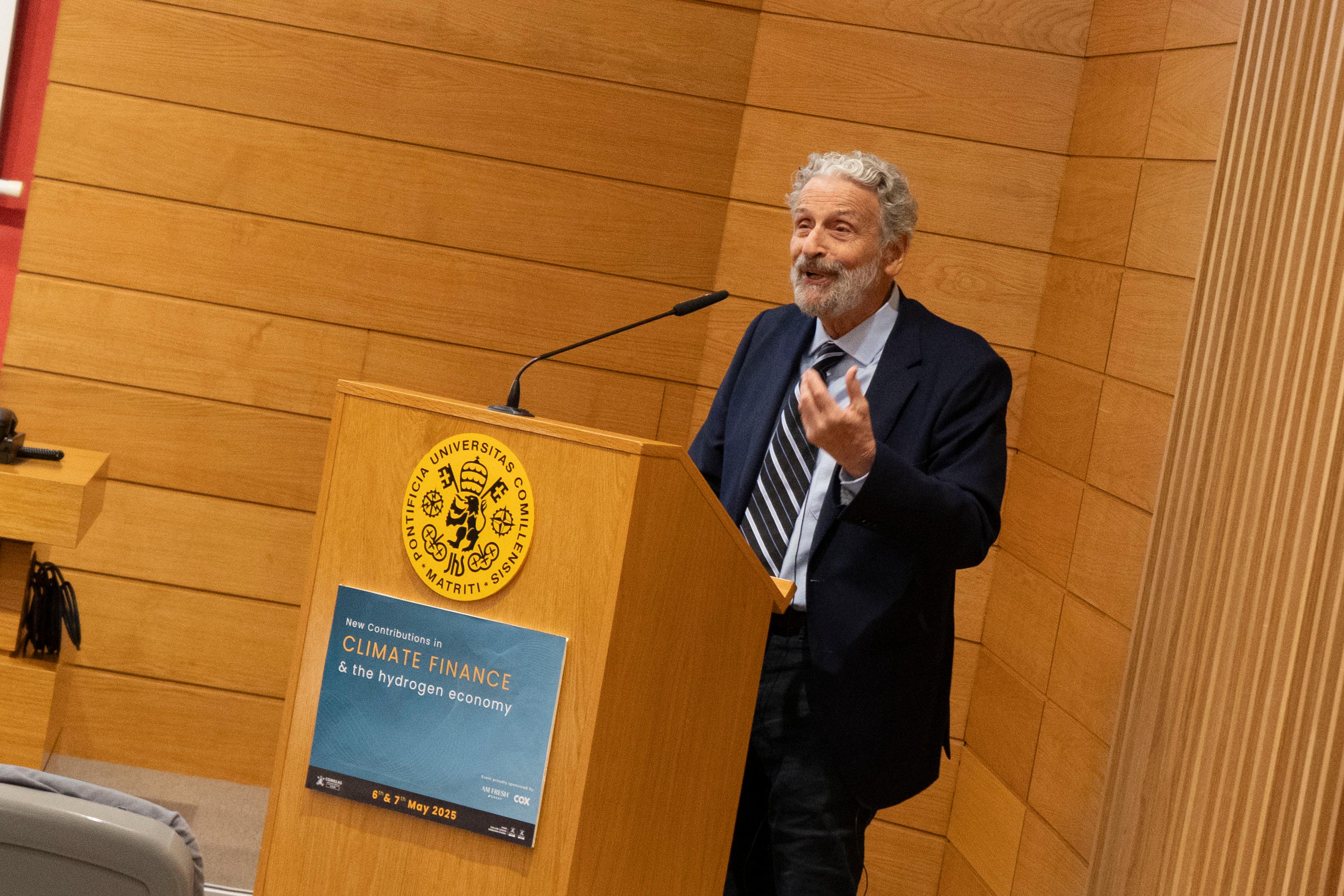 Un hombre habla desde un podio en un evento sobre finanzas climáticas y economía del hidrógeno.