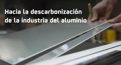 La imagen muestra a alguien trabajando con láminas de aluminio en un contexto relacionado con la industria.