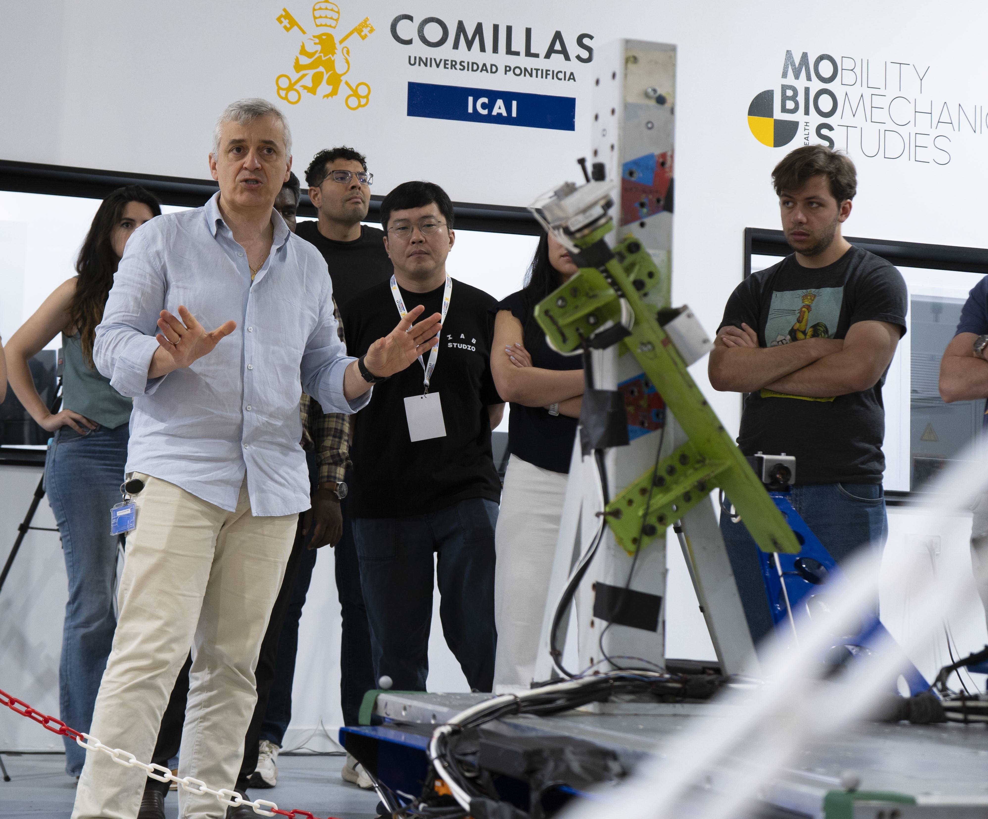 Un grupo de personas observa una presentación sobre tecnología robótica en un entorno académico.