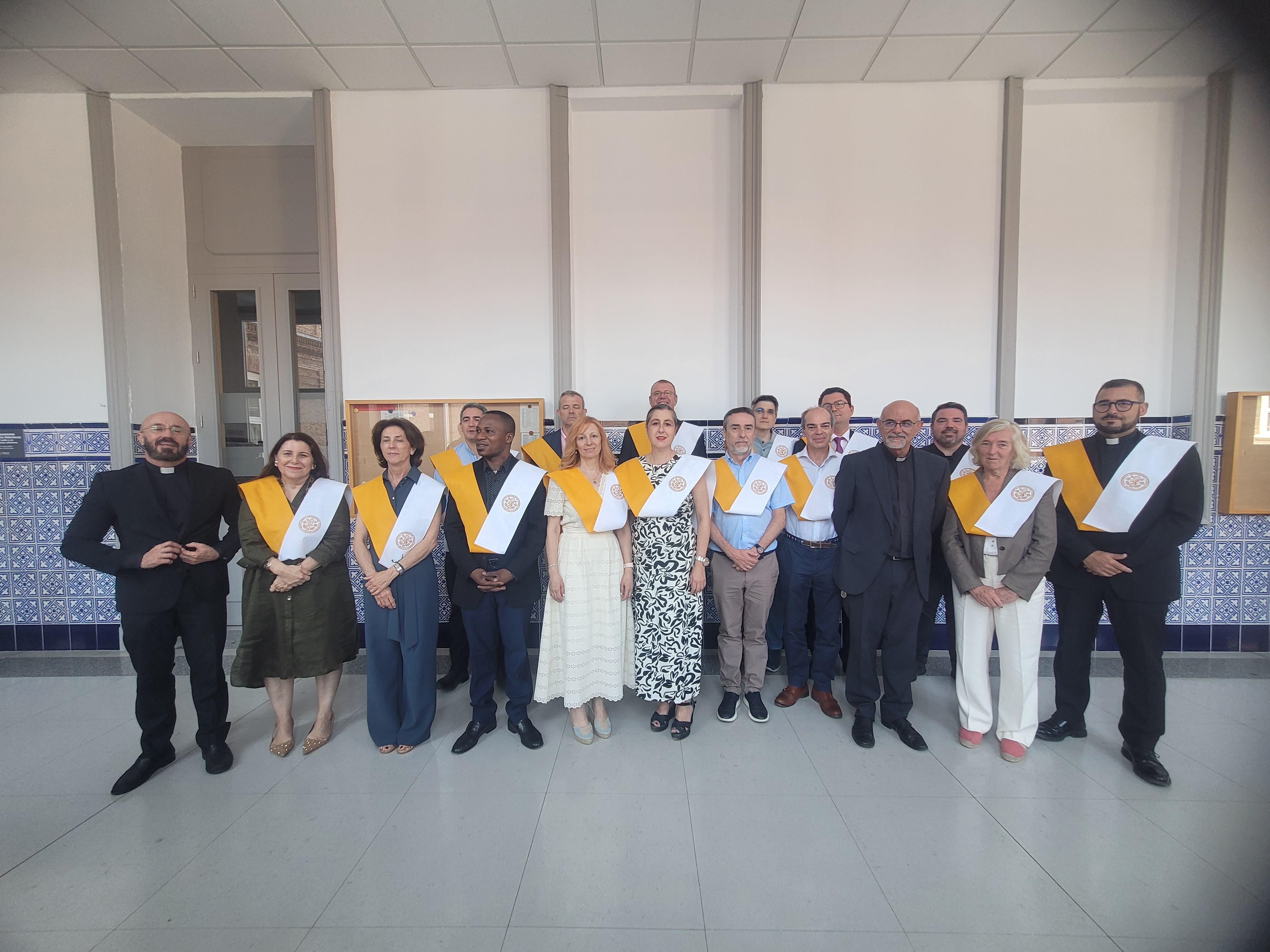 Grupo de personas posando con sábanas amarillas y blancas en un evento formal.