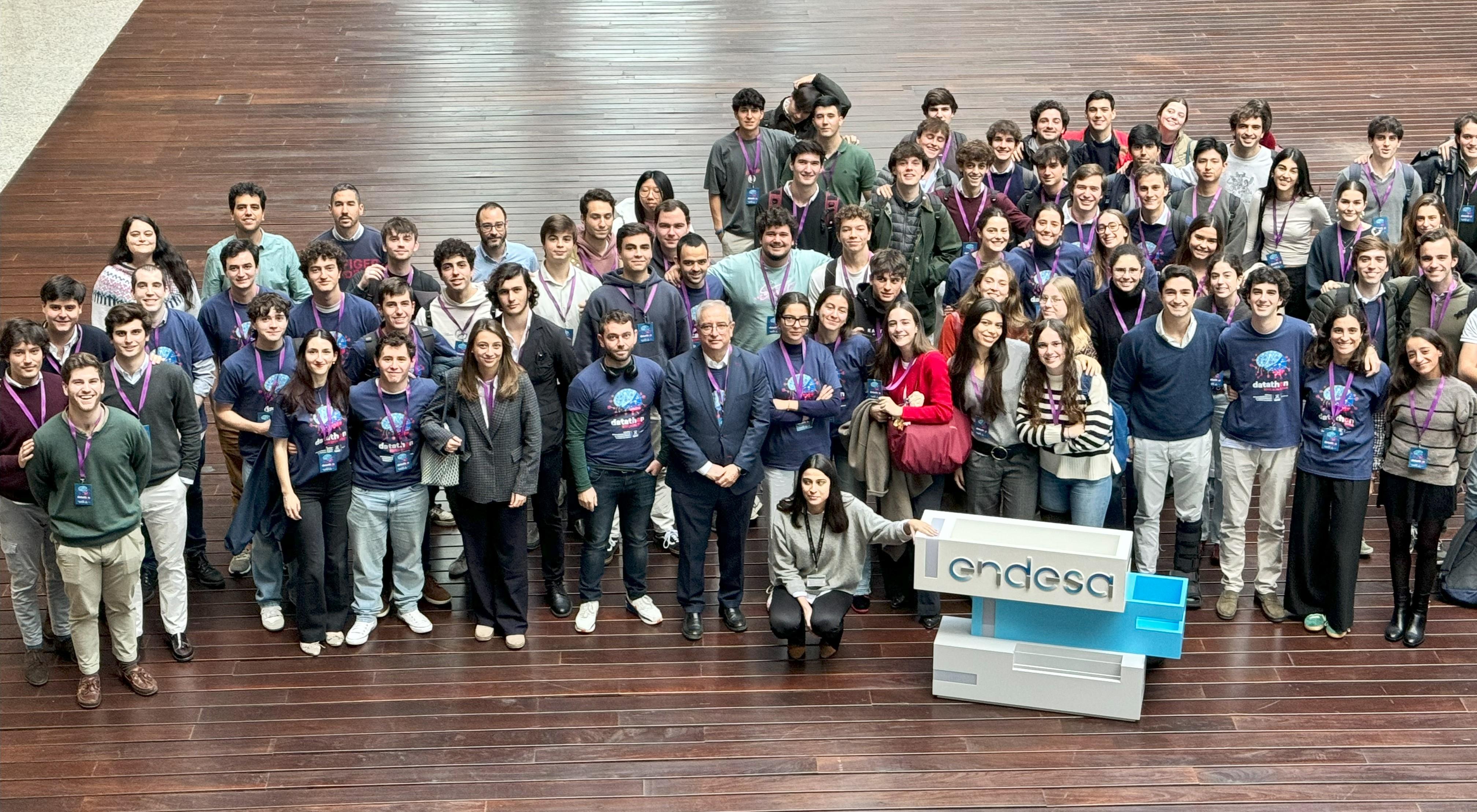 Un grupo grande de personas posa sonriente en un espacio interior amplio frente a un mostrador con el logo de Endesa.