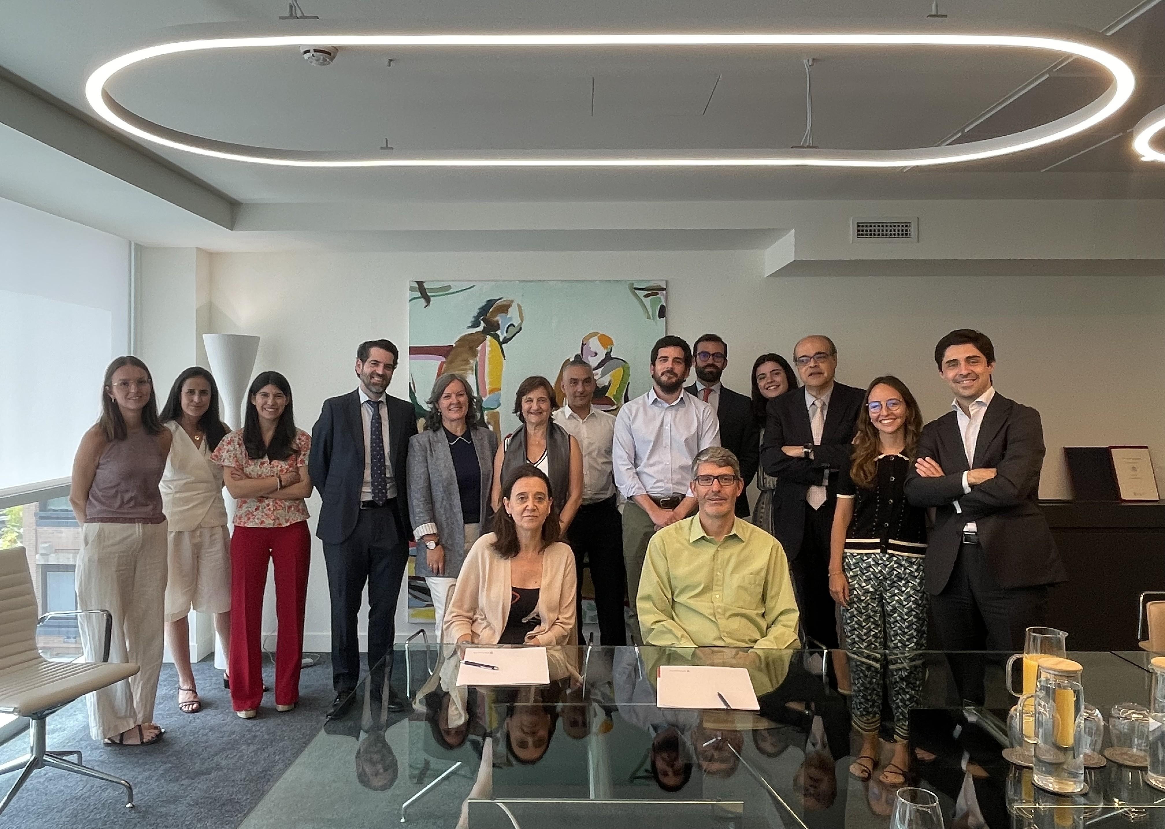 Un grupo de personas sonrientes posando en una sala de reuniones moderna.