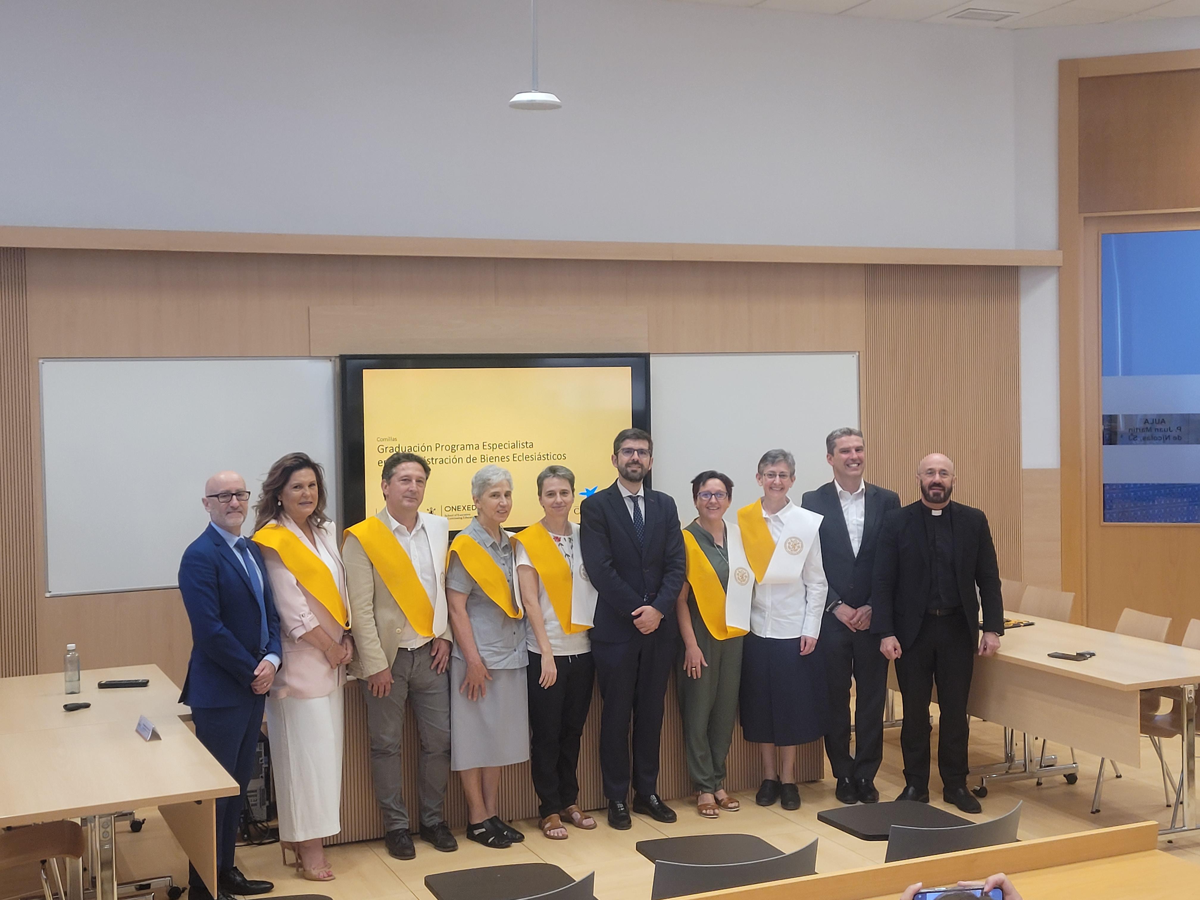 Un grupo de personas con togas amarillas se presentan en un evento académico.