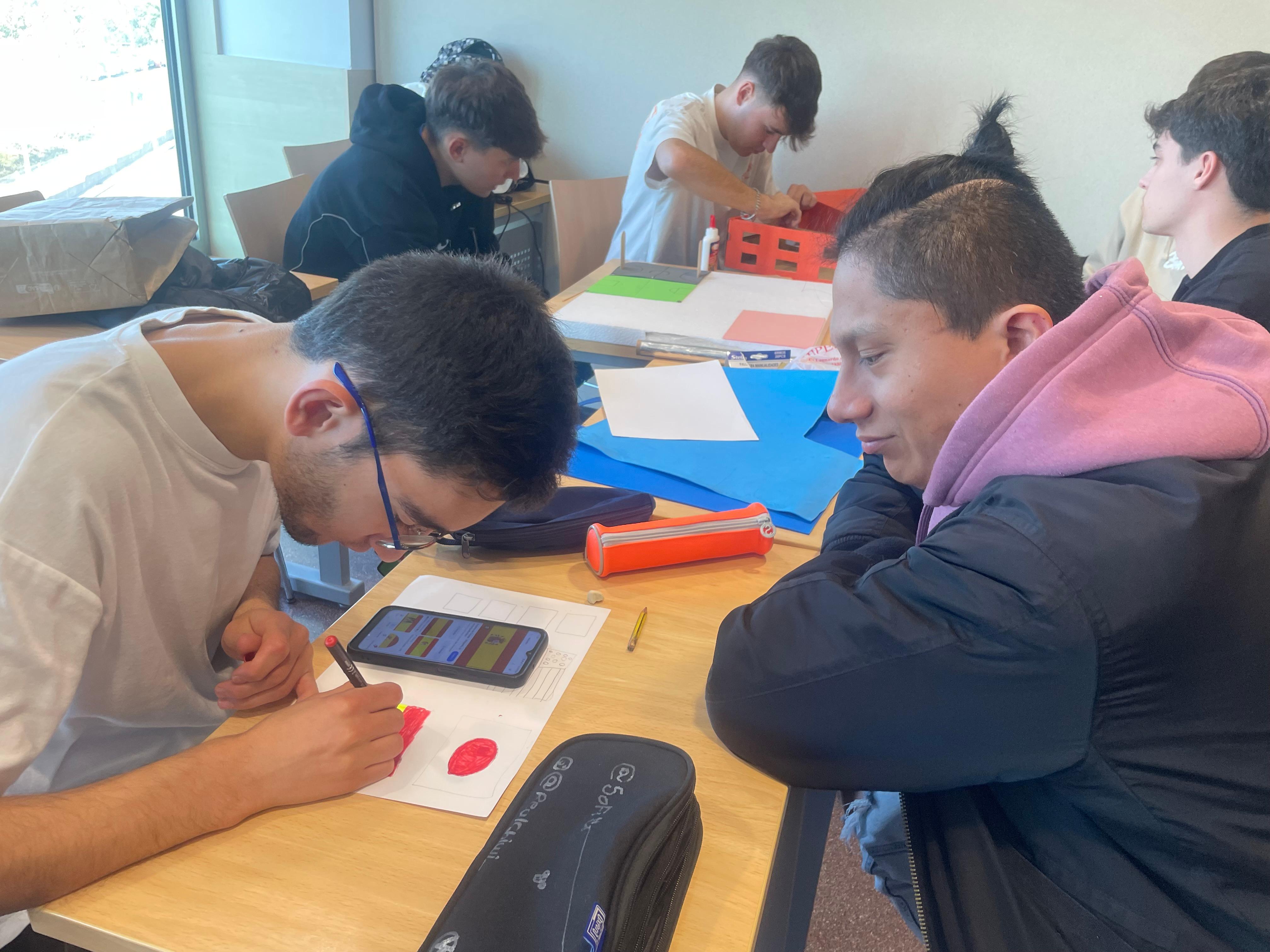 Dos estudiantes colaboran usando una tableta en una sala de clases mientras otros estudian al fondo.