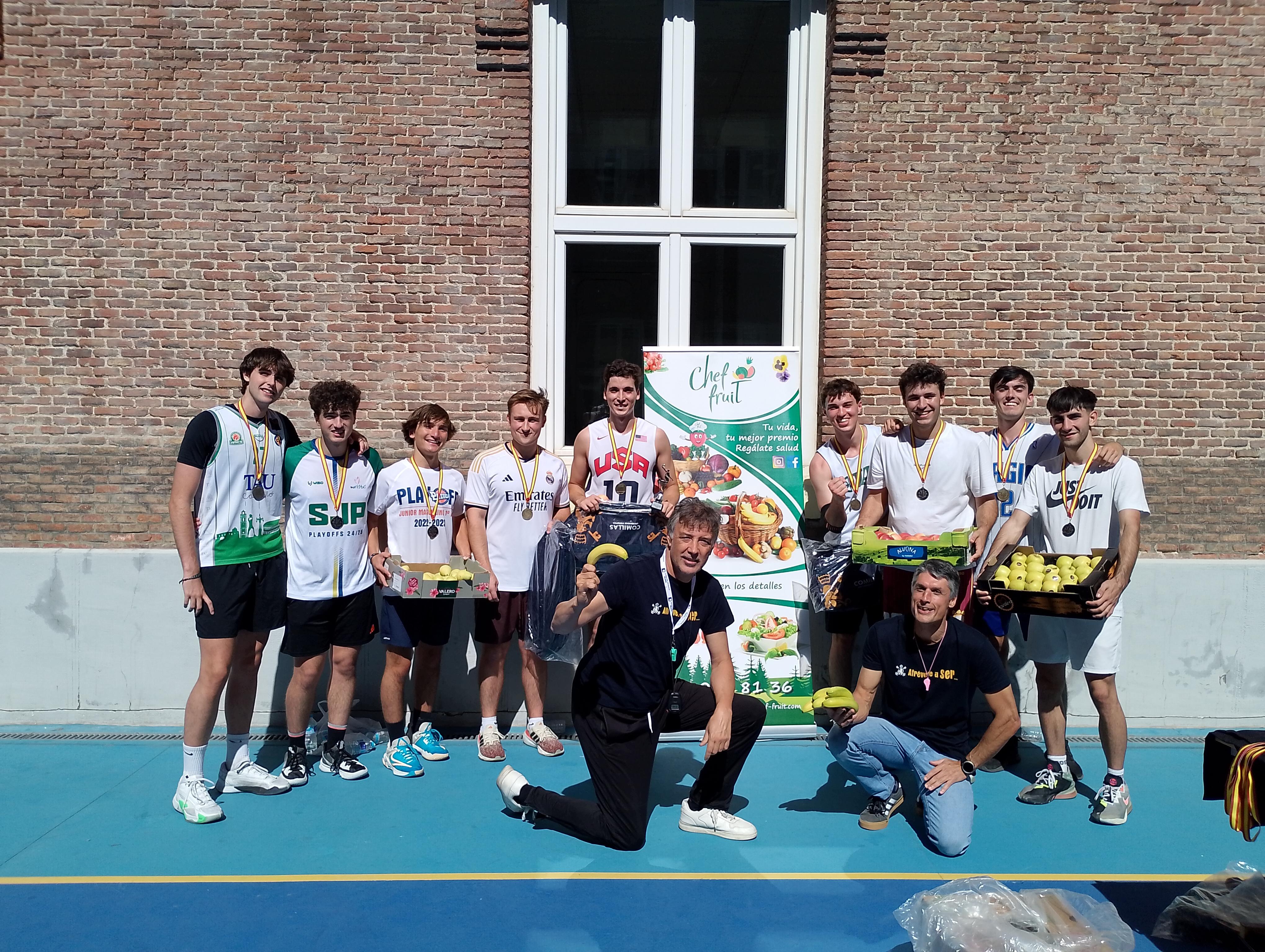 Grupo de jóvenes celebrando con medallas en una cancha de baloncesto.