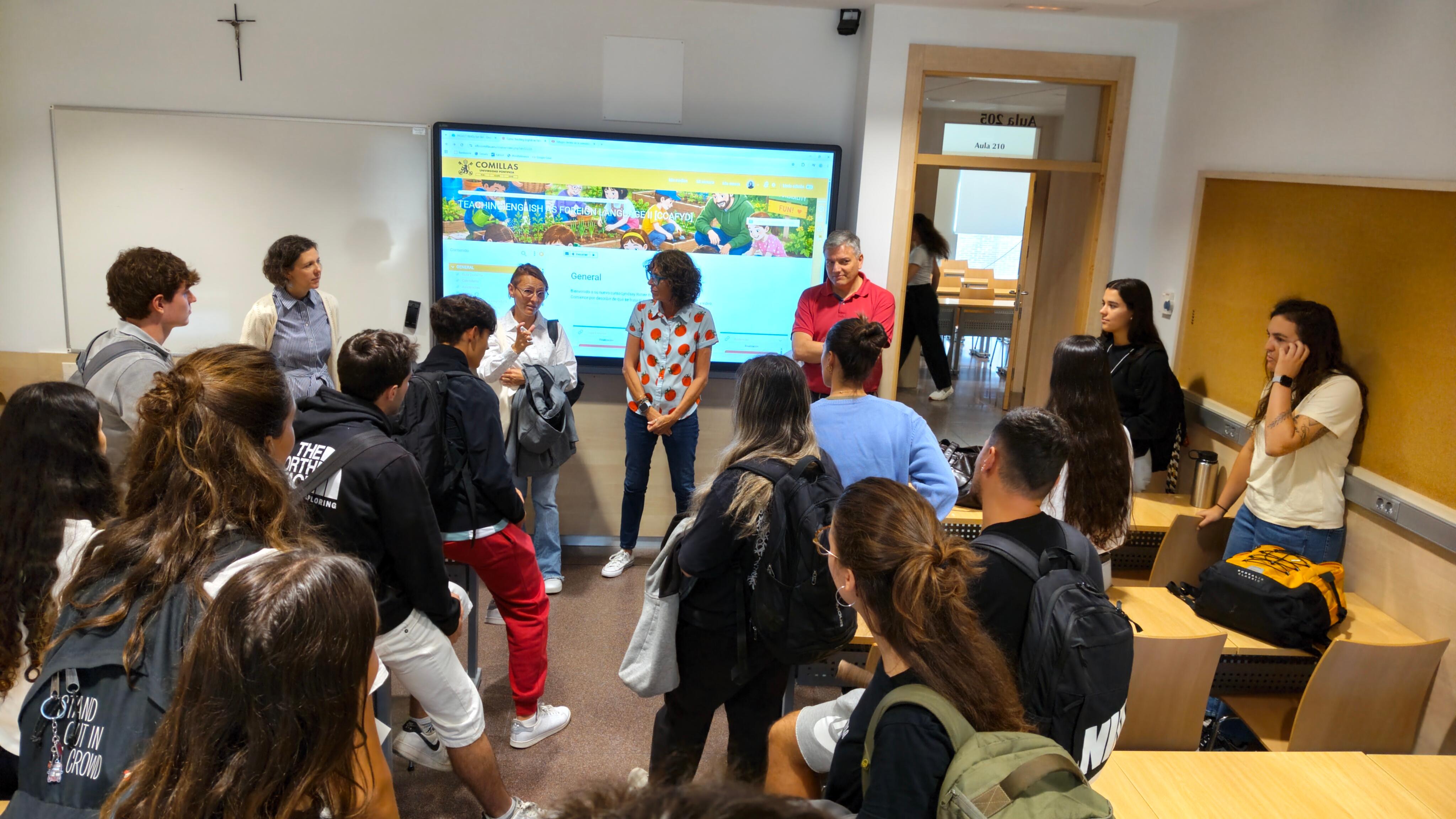 Un grupo de estudiantes y profesores interactuando en un aula moderna.
