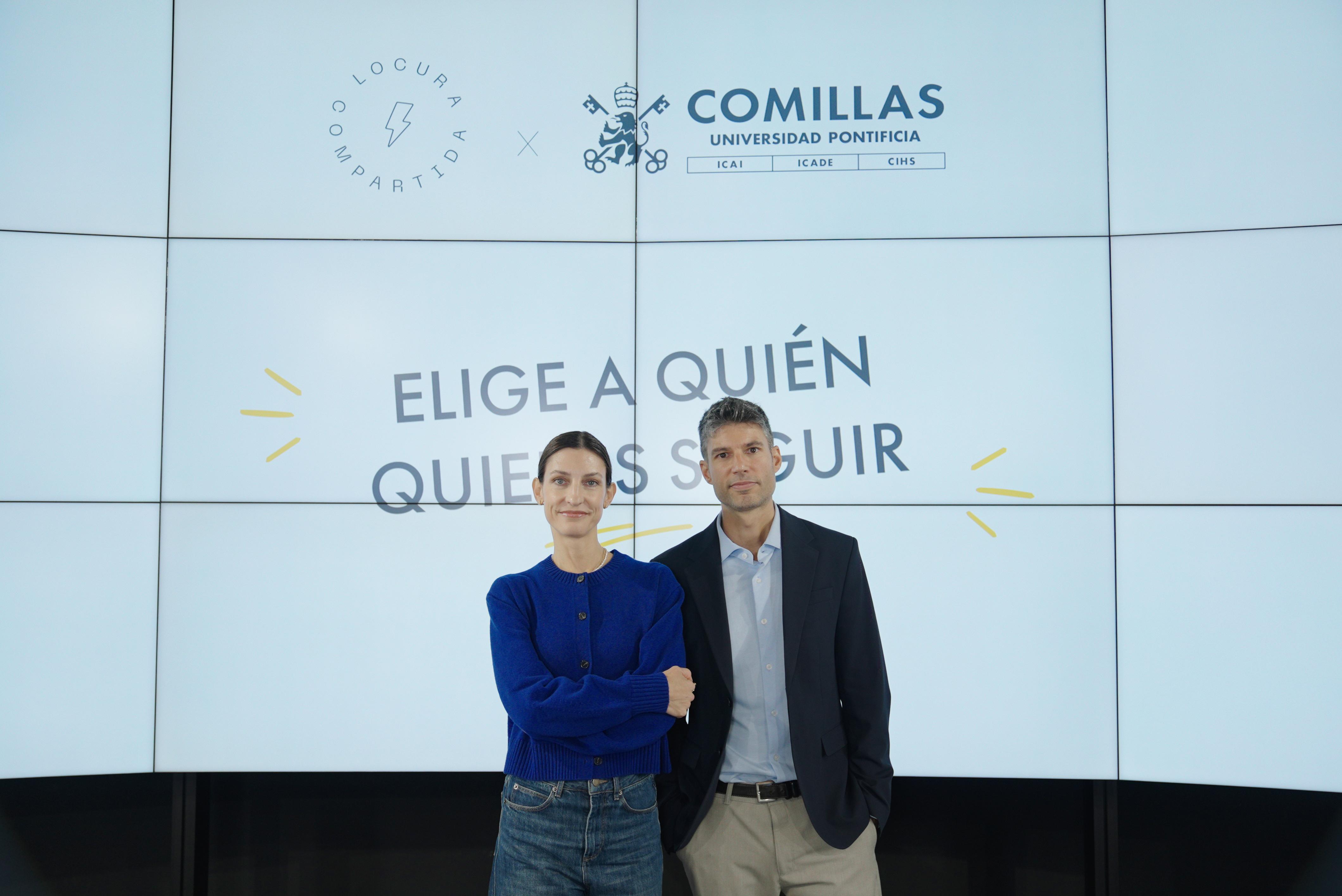 Una pareja de personas se presenta frente a una pancarta que invita a elegir a quién seguir.