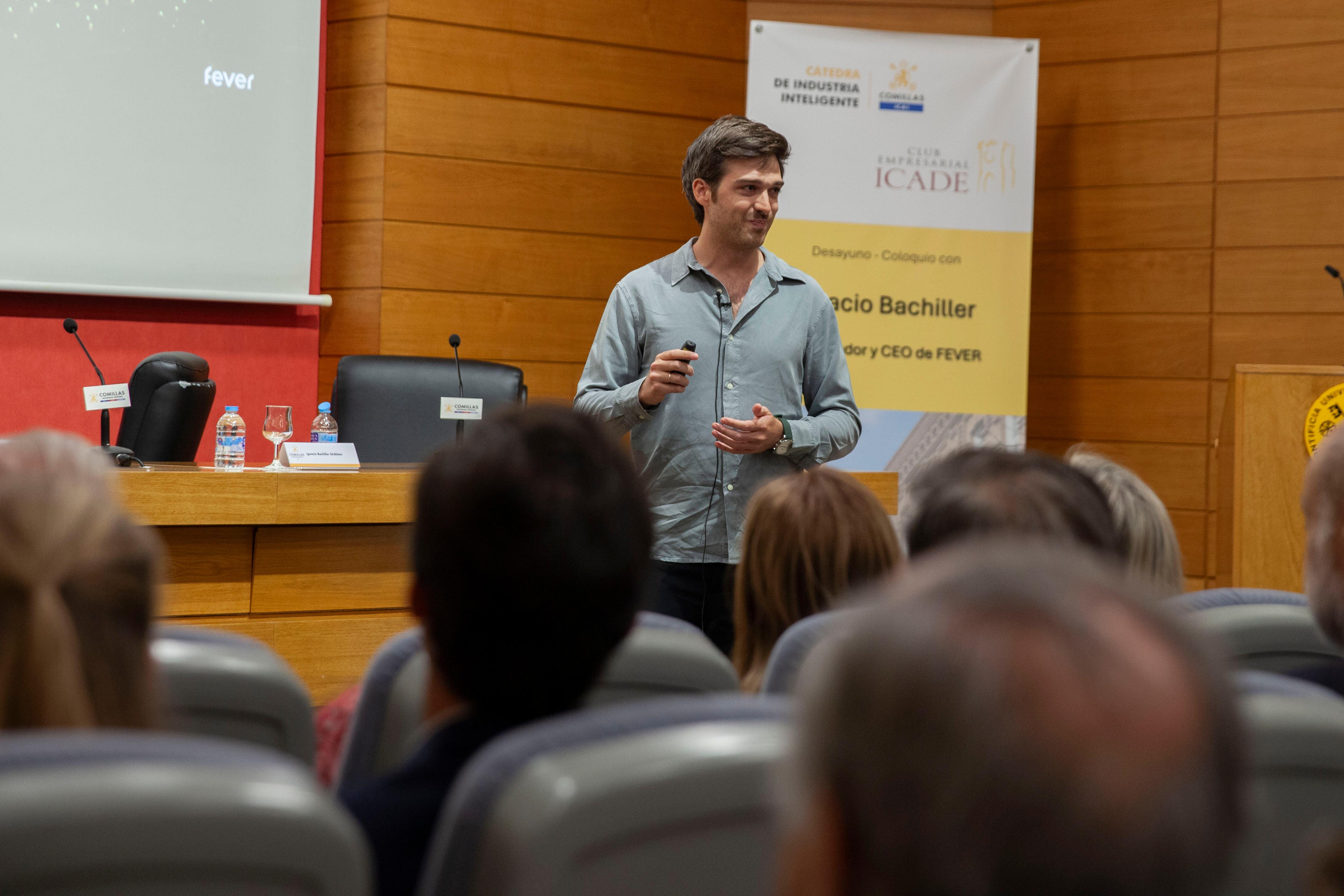 Un hombre presenta en un evento mientras el público lo escucha atentamente.