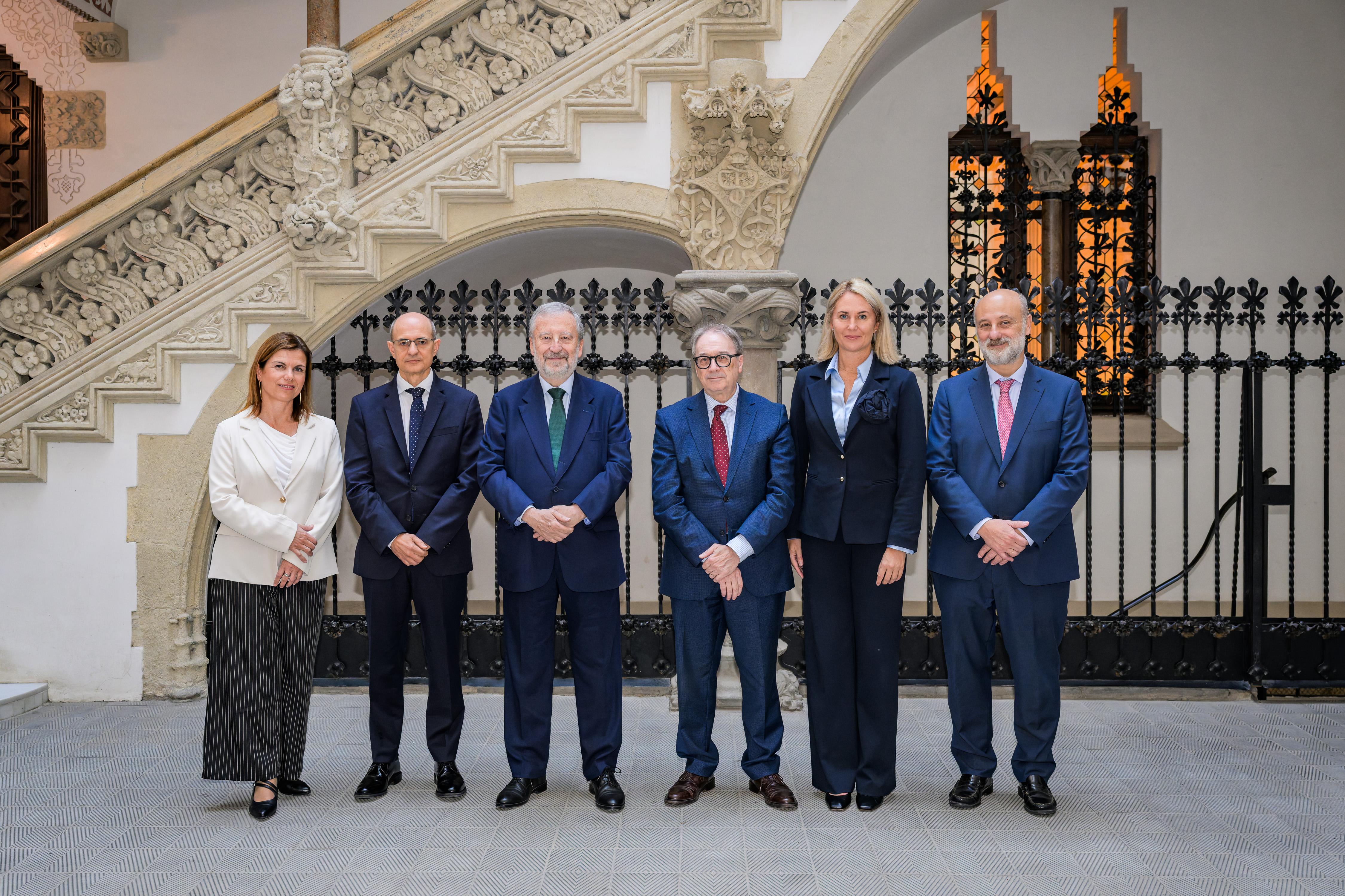 Un grupo de seis personas posando en un elegante entorno arquitectónico.