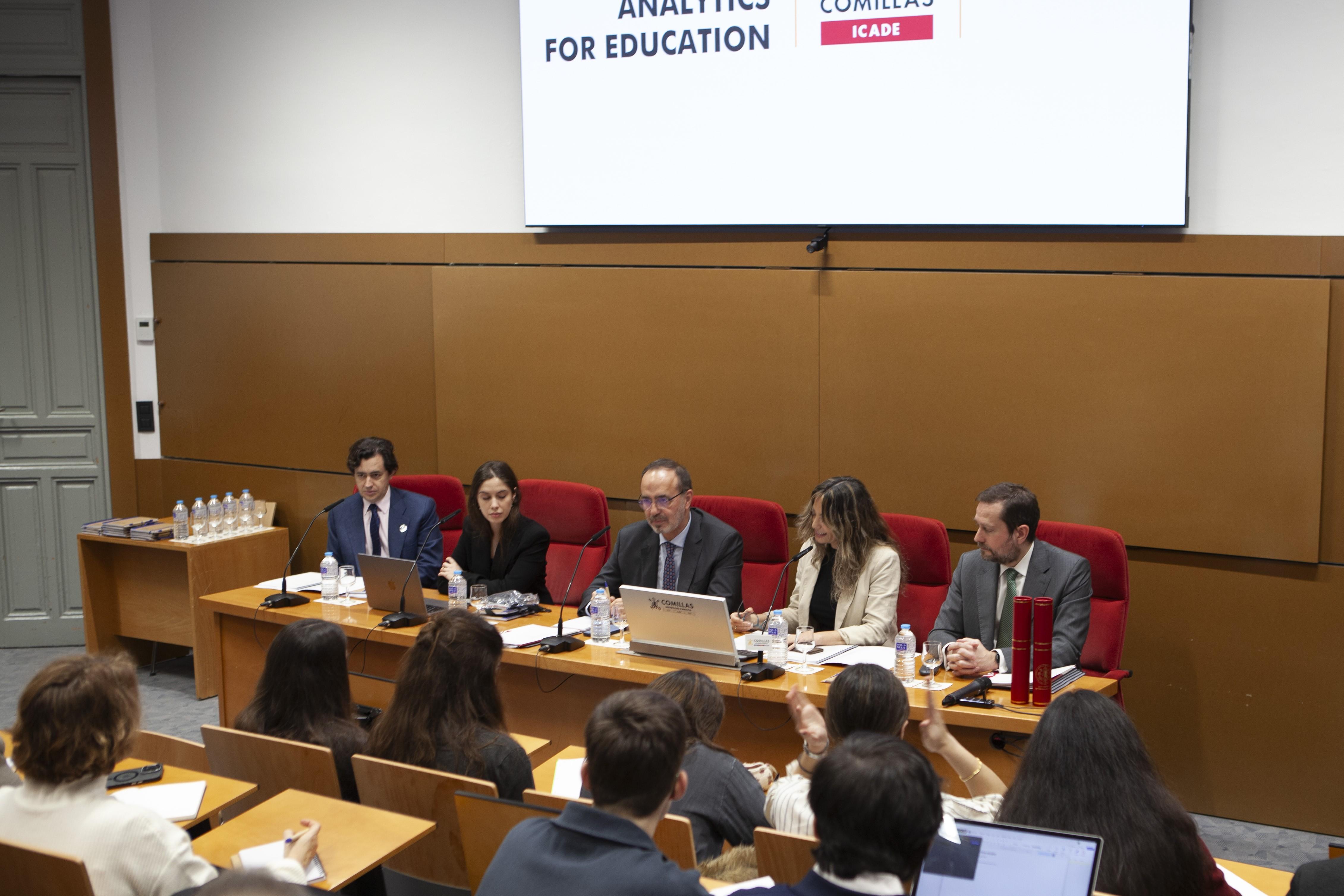 Una mesa redonda con varios ponentes discutiendo sobre analíticas para la educación en un aula.