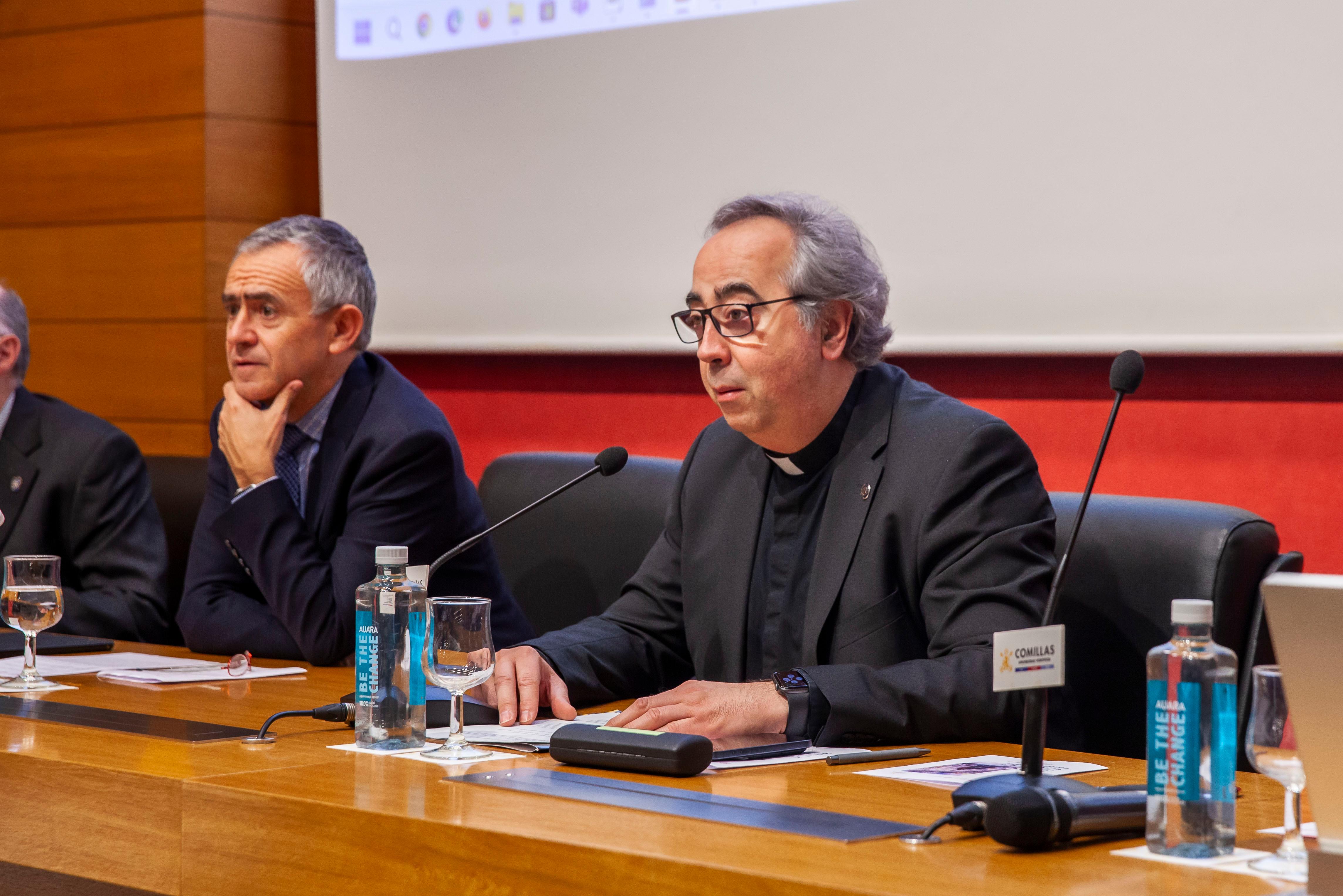 Una conferencia con varias personas sentadas tras un escritorio, una de ellas hablando ante un público.