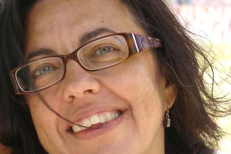 Close-up portrait of a smiling woman wearing glasses.