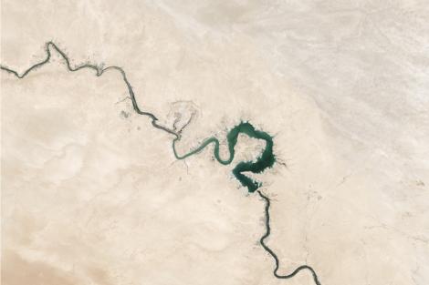 Vista aérea de un río serpenteante con áreas verdes en un entorno desértico.