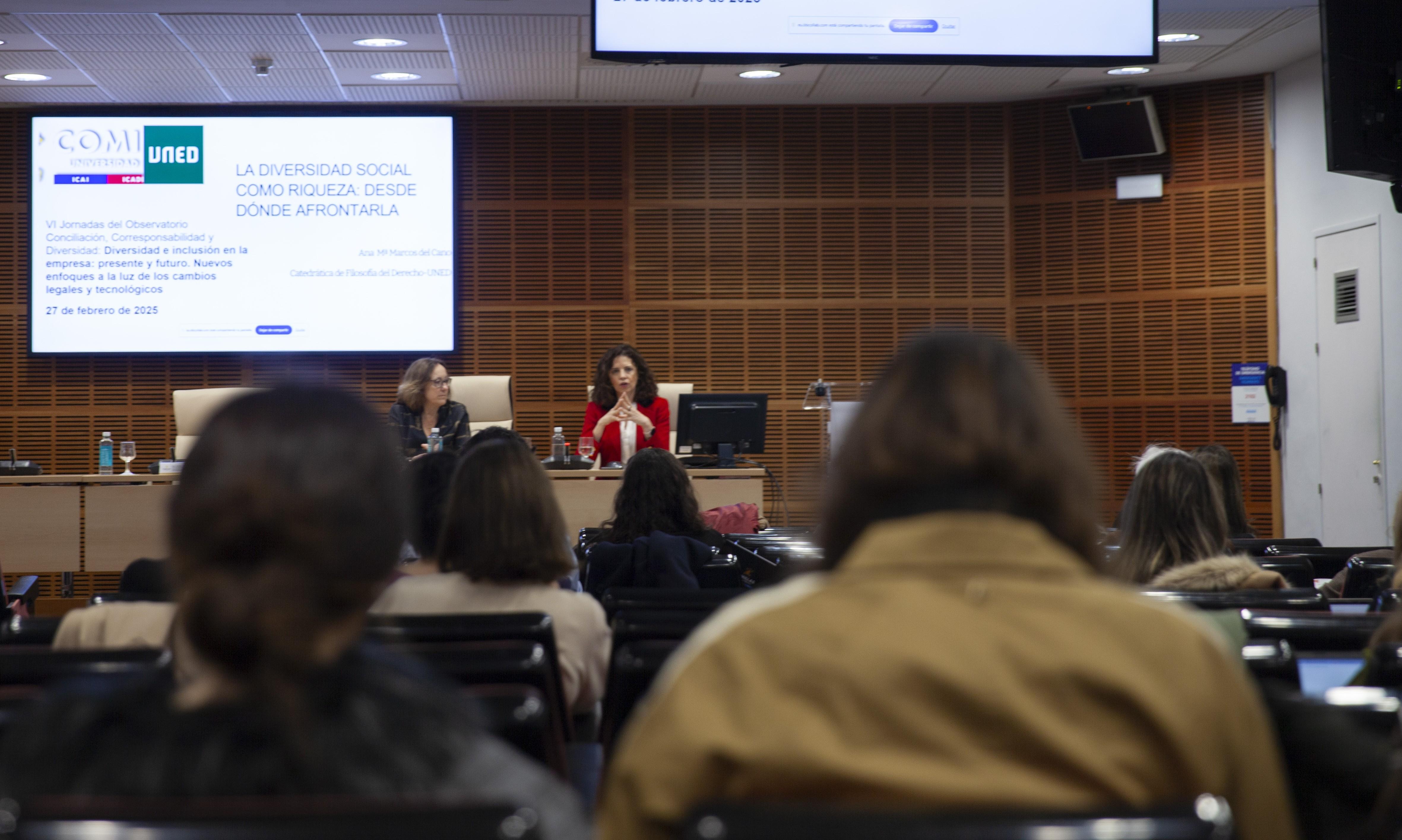 Una conferencia sobre la diversidad social con panelistas en el escenario y una audiencia atenta.