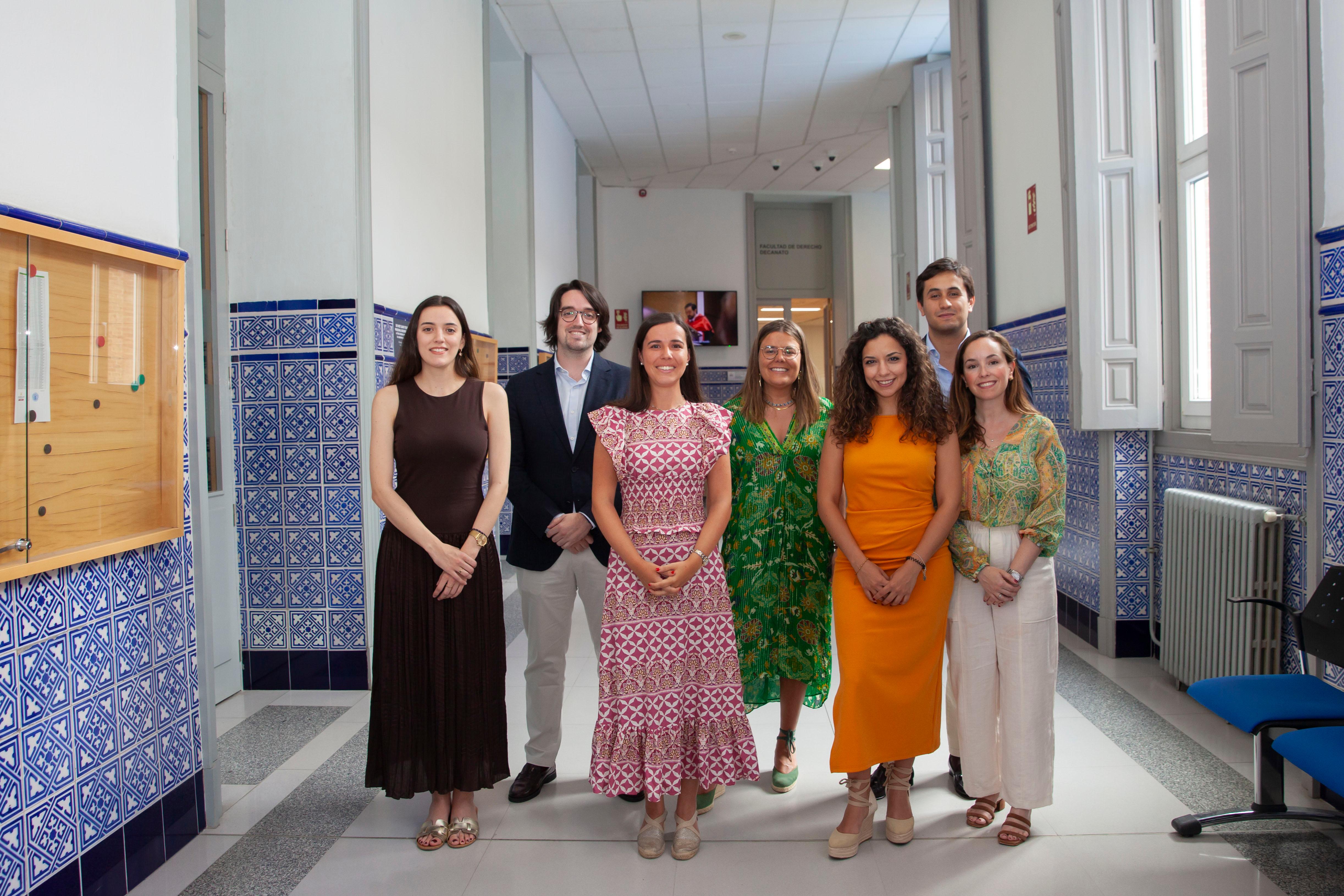 Un grupo de siete personas posando en un pasillo con azulejos decorativos.