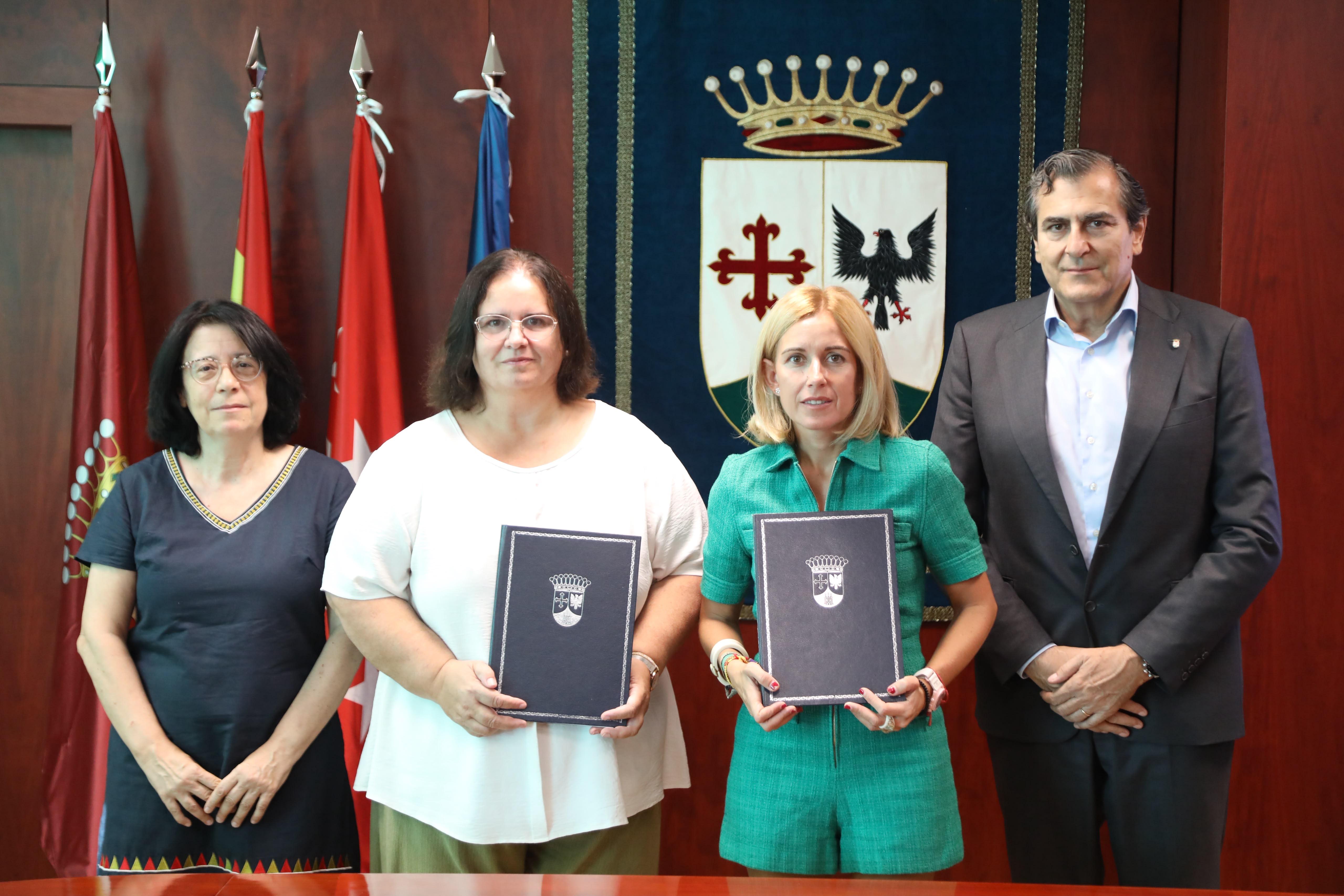 La imagen muestra a cuatro personas posando en un entorno oficial, sosteniendo documentos en un ambiente institucional.