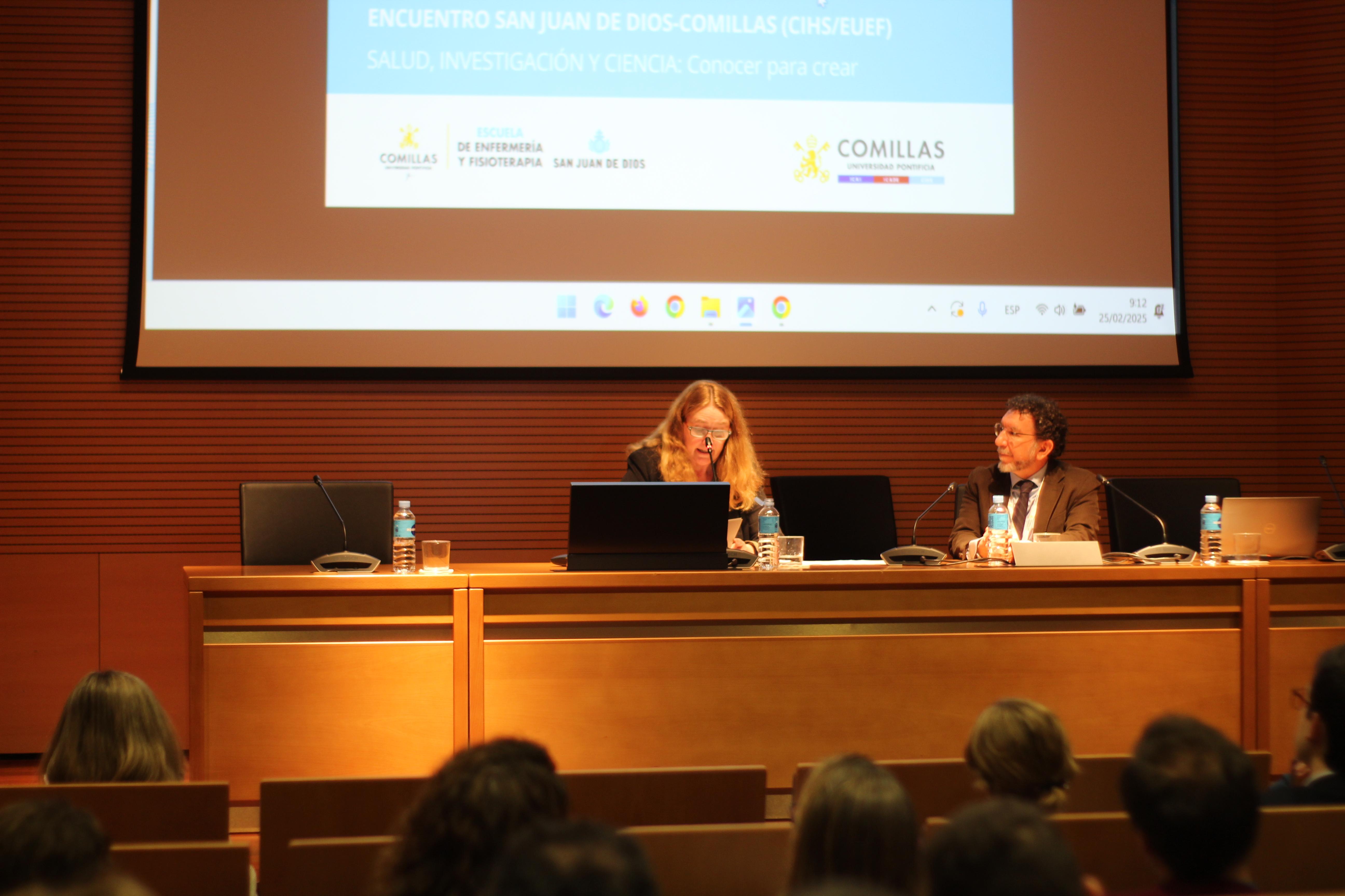 Una conferencia en un auditorio con ponentes y público sentado.