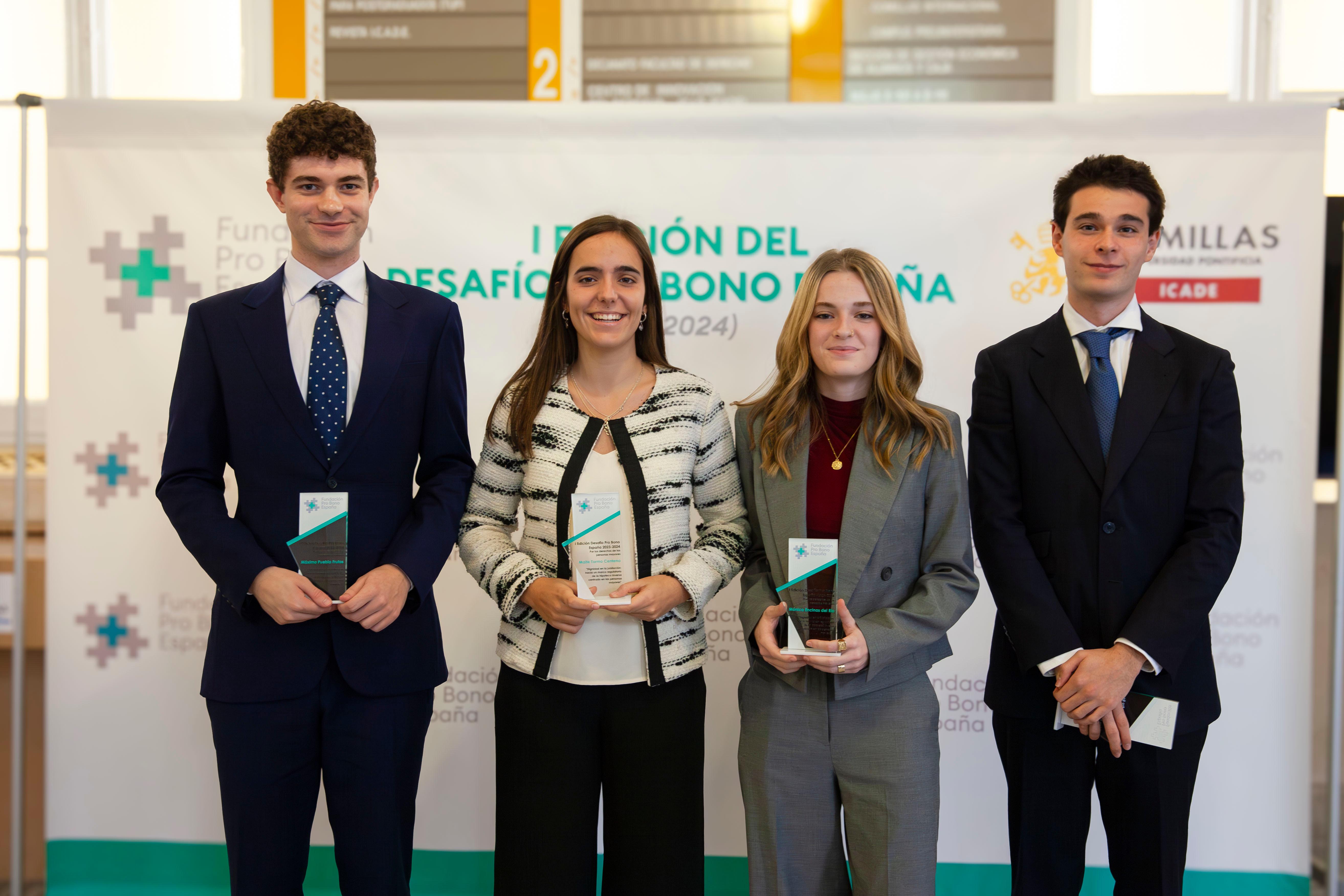 Cuatro jóvenes profesionales posan con premios en manos frente a un cartel de la Fundación Pro Bono.