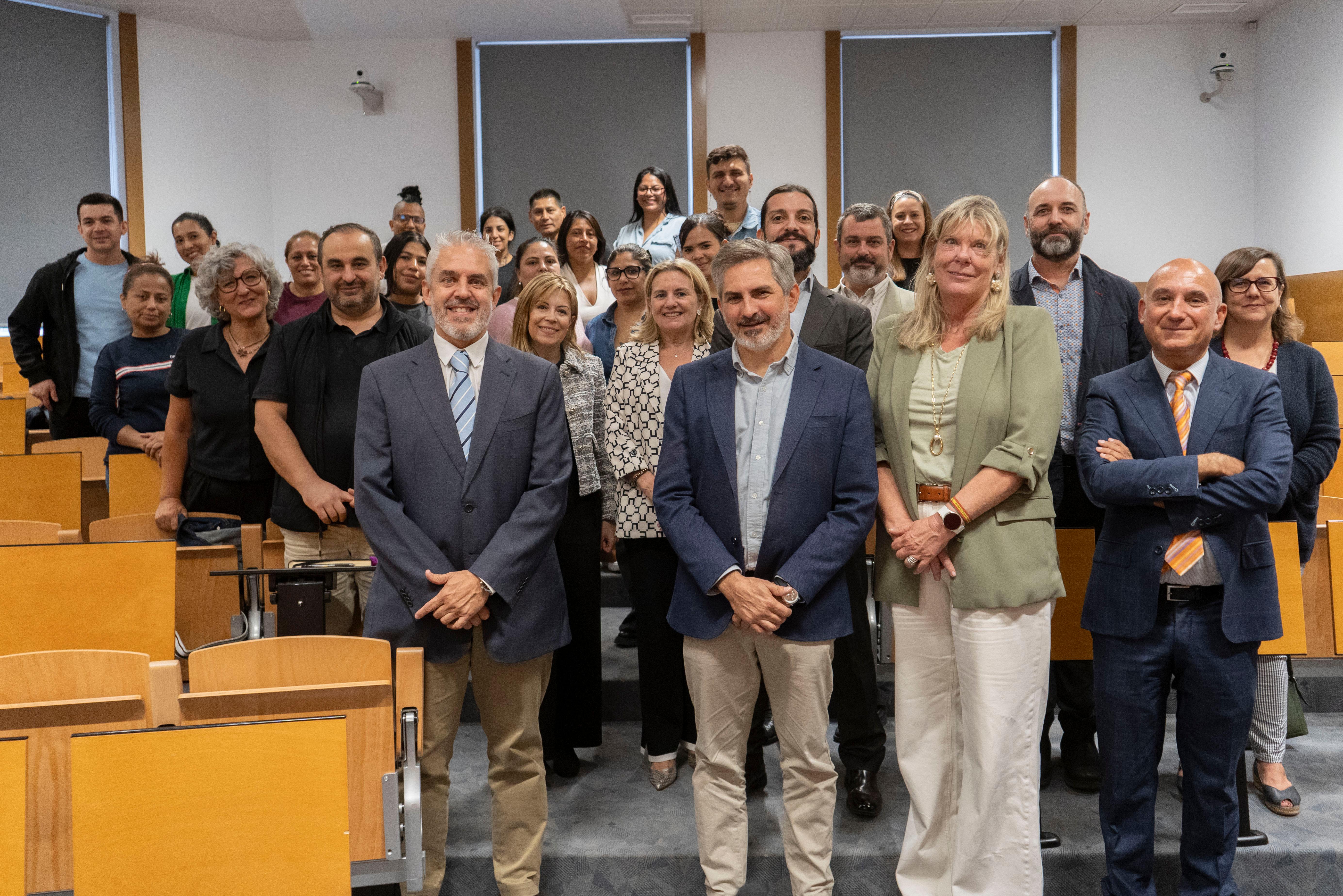 Un grupo de personas posando juntas en un aula.