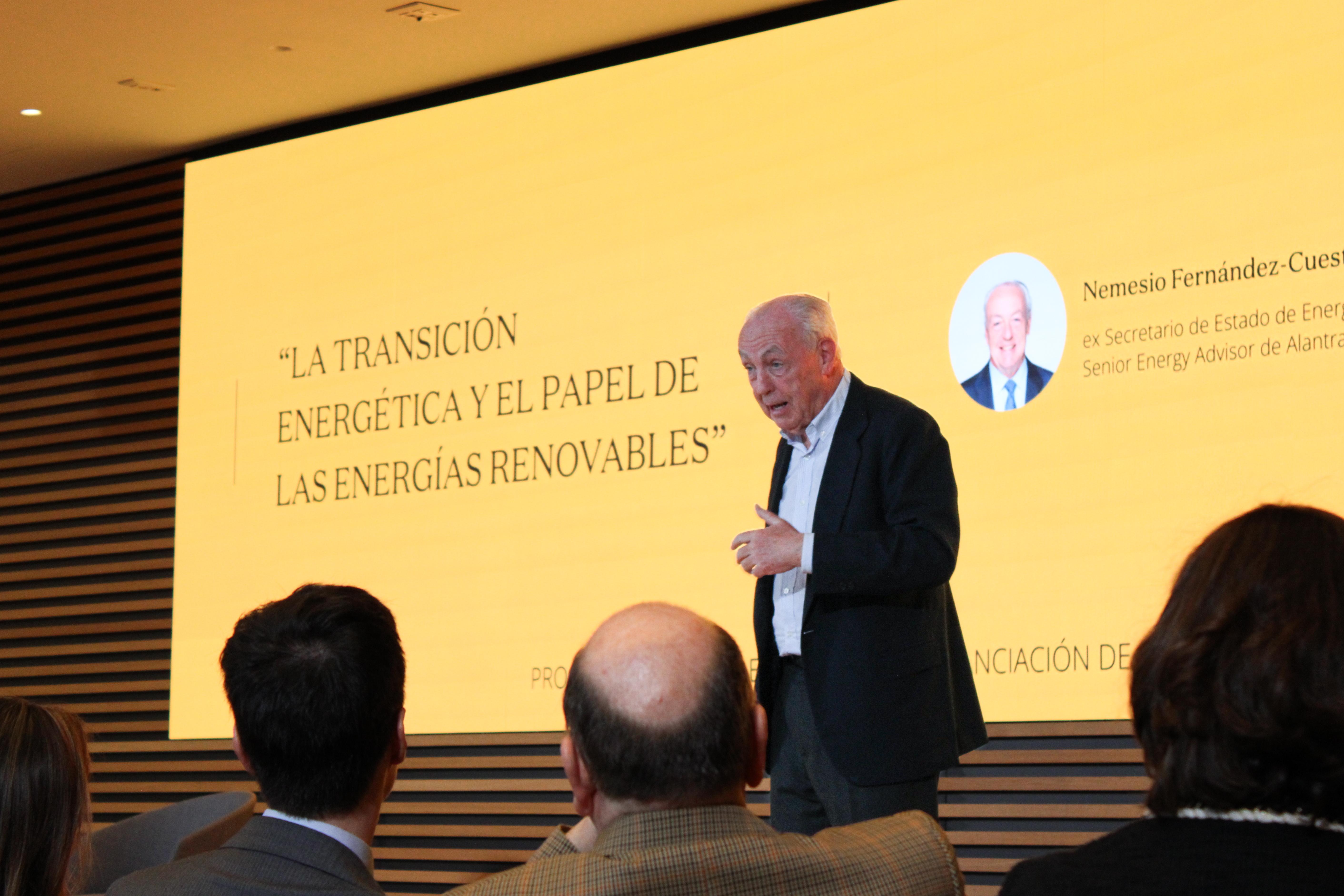 Un orador presenta sobre la transición energética y las energías renovables ante un público atento.