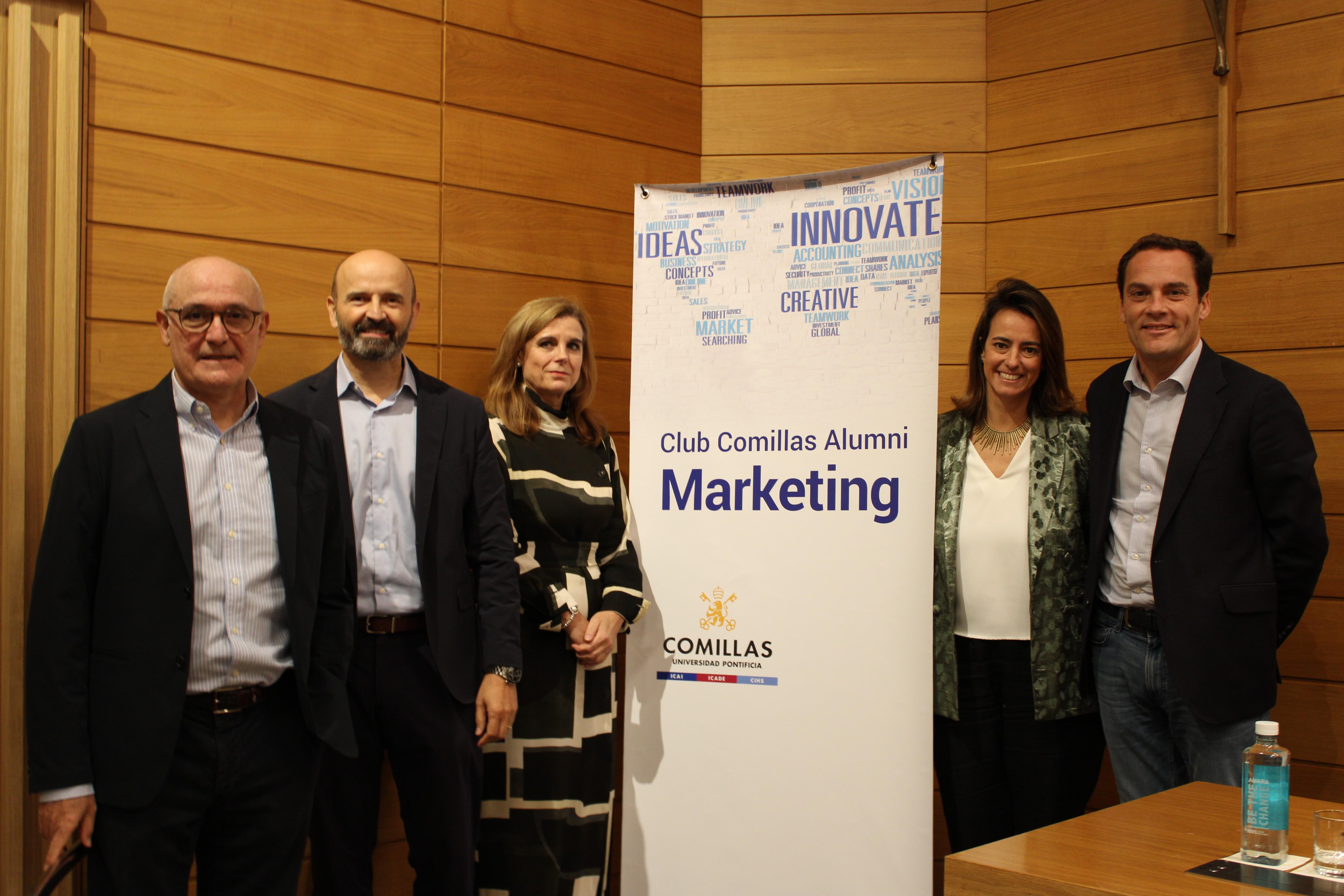 Five people standing in front of a marketing event banner.