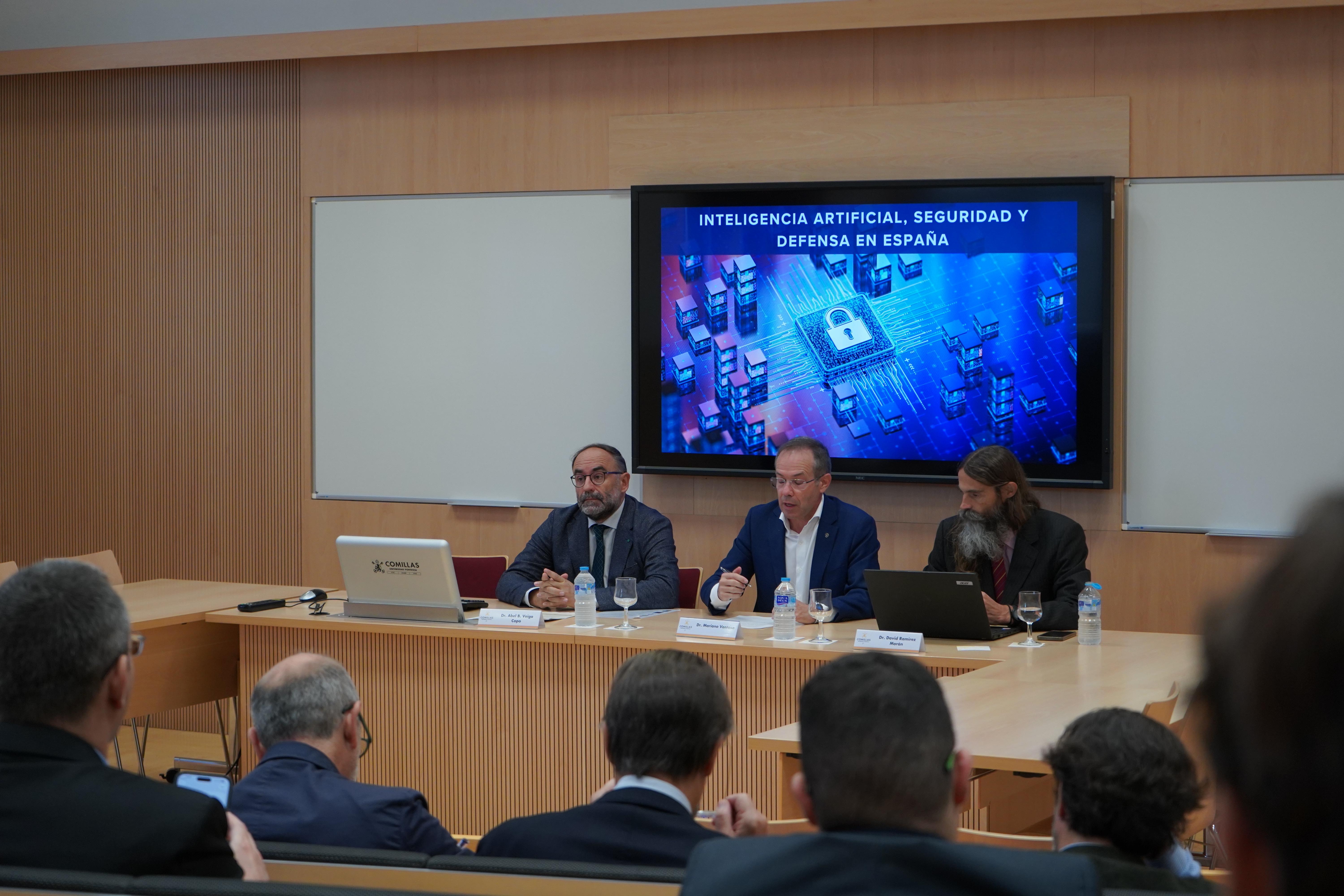 Un panel de discusión sobre inteligencia artificial, seguridad y defensa en España, con tres ponentes visibles frente a una audiencia.