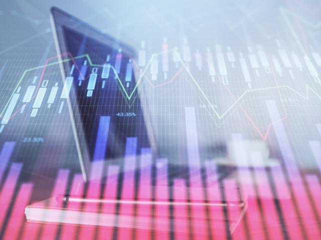 Graphical representation of financial stock market data with rising and falling lines on a blurred background.