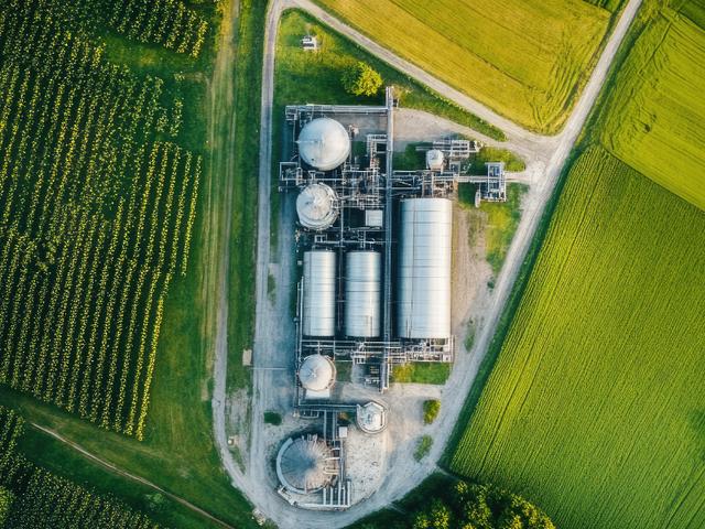 Vista aérea de una planta industrial rodeada de campos verdes.