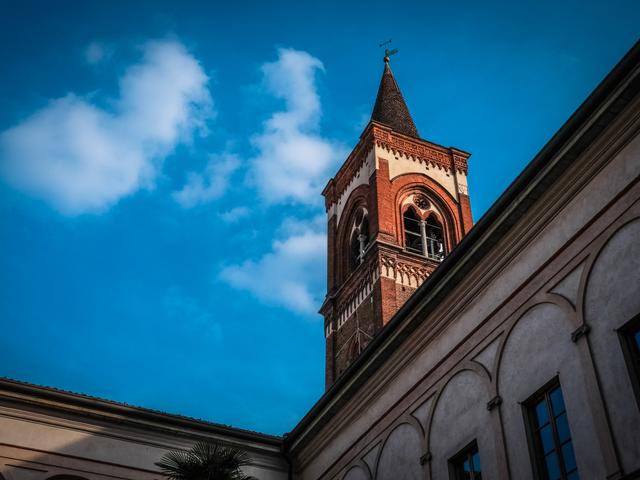 Una imagen de una torre de iglesia con un fondo de cielo azul y algunas nubes.