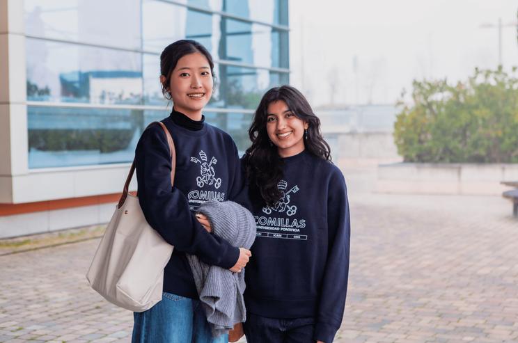 Dos jóvenes sonrientes posan juntas en un entorno urbano