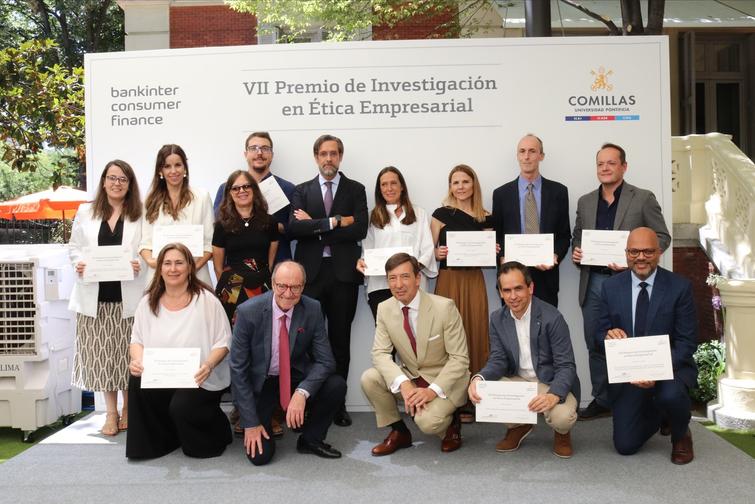 A group of people holding certificates posing for a photo at an award ceremony for business ethics research.