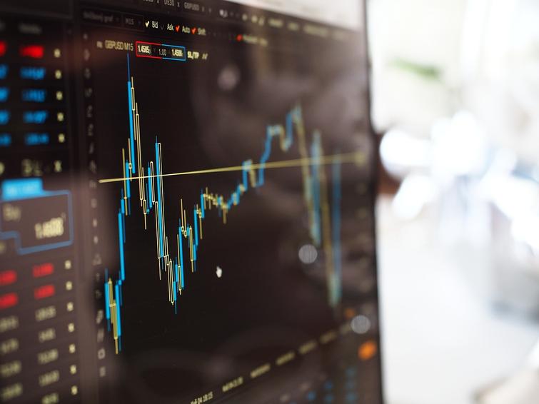 Close-up view of a computer monitor displaying financial graphs and stock market data.