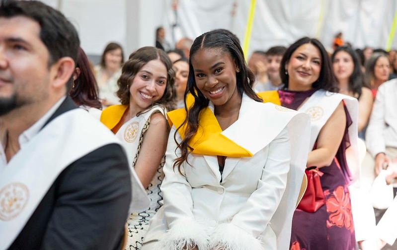 Grupo de personas sonrientes en un evento de graduación.