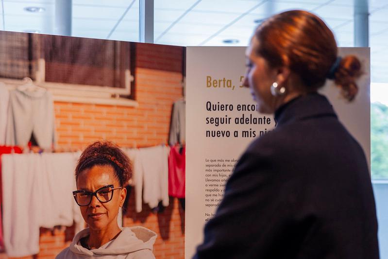 Una mujer observa una fotografía de otra mujer con un mensaje inspirador sobre seguir adelante.