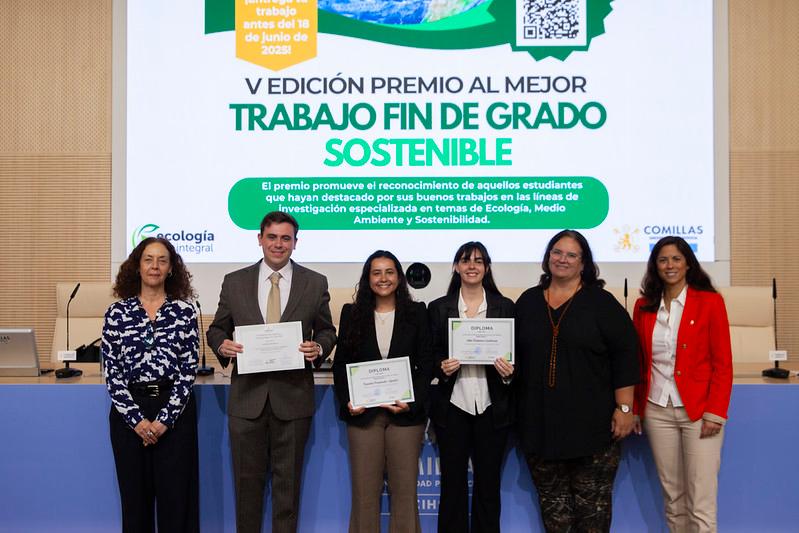 Un grupo de personas sonríe mientras sostiene certificados en una ceremonia de premiación.