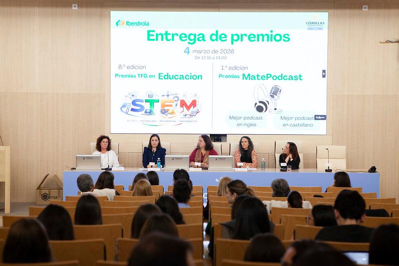 Una ceremonia de entrega de premios en la que participan varias mujeres de pie detrás de una mesa y una audiencia atenta.