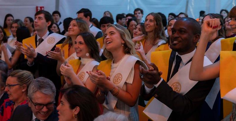 Una multitud de graduados aplaudiendo en una ceremonia de graduación.