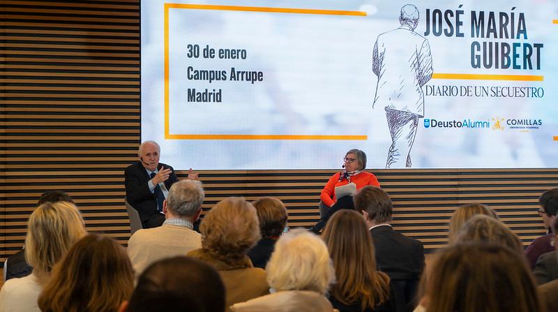 Dos personas hablando en un evento sobre el libro 'Diario de un Secuestro' en el campus Arrupe, Madrid.