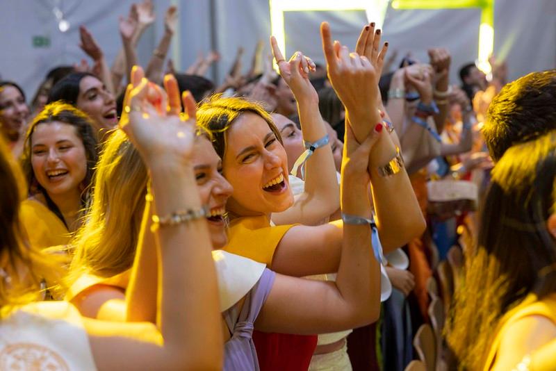 Un grupo de jóvenes celebra con alegría durante un evento festivo.