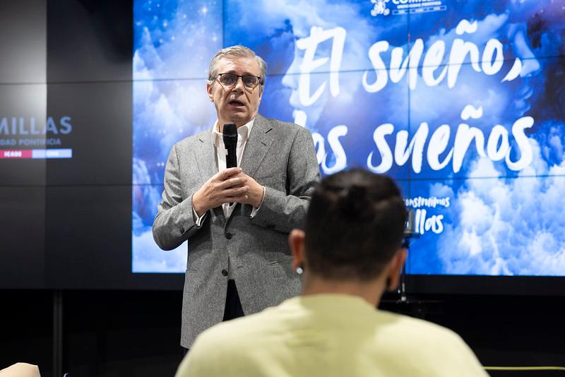 Un hombre está dando una charla frente a un público en un evento sobre sueños.