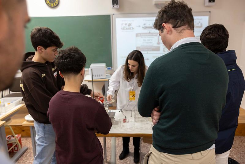 Un grupo de estudiantes observa a una persona que realiza una demostración en un aula.