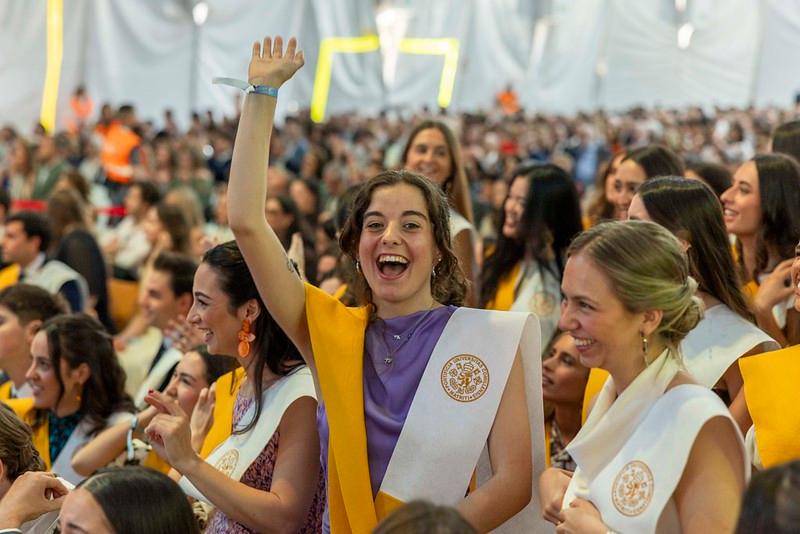 Un grupo de personas sonrientes y celebrando en un evento de graduación.