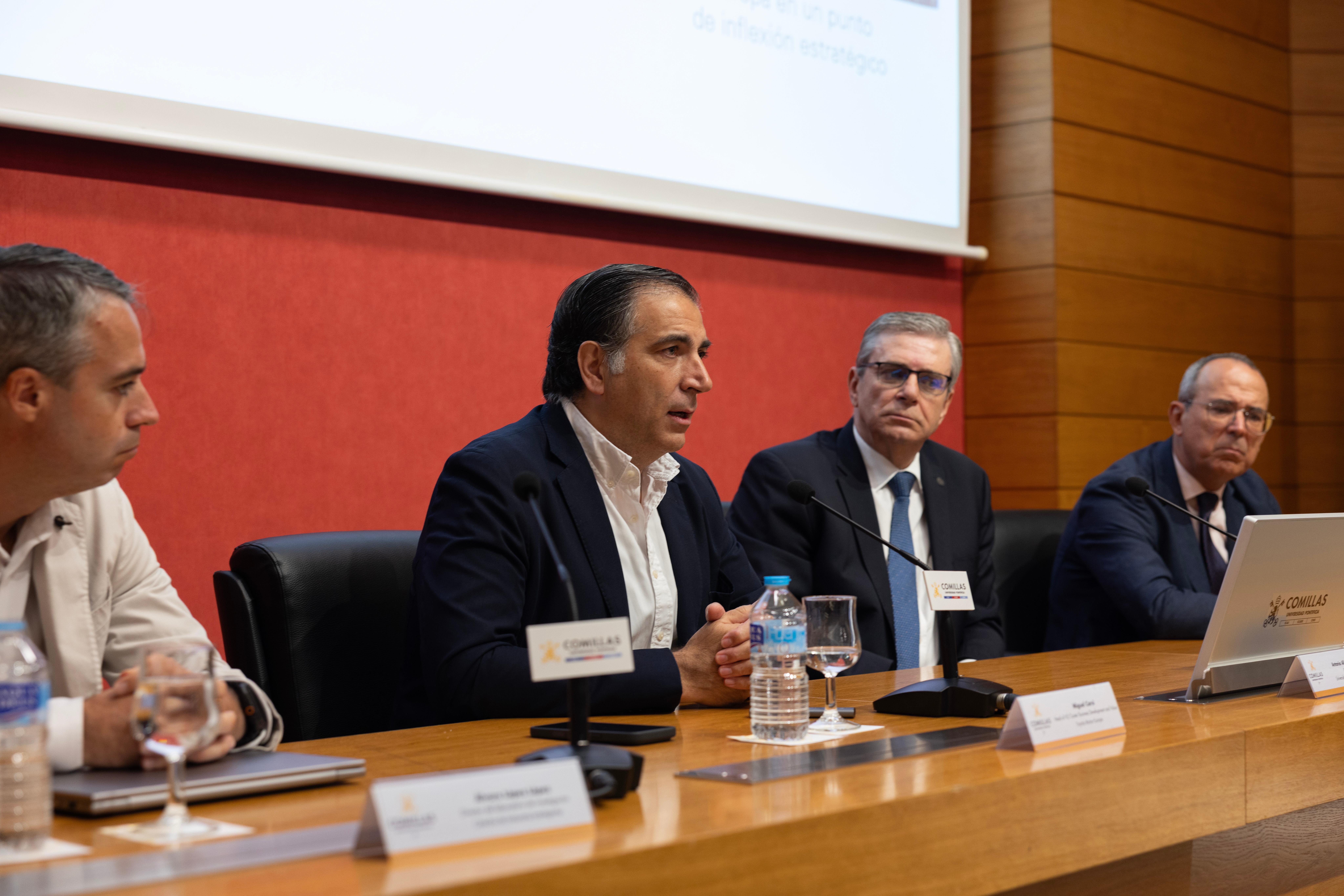 Un grupo de personas en una mesa durante un evento o conferencia discutiendo temas relevantes.
