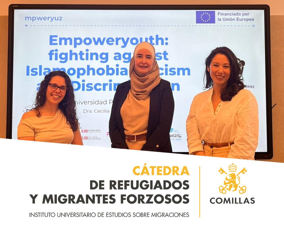 Tres mujeres posan frente a una pantalla que muestra un evento sobre la lucha contra la islamofobia y la discriminación.